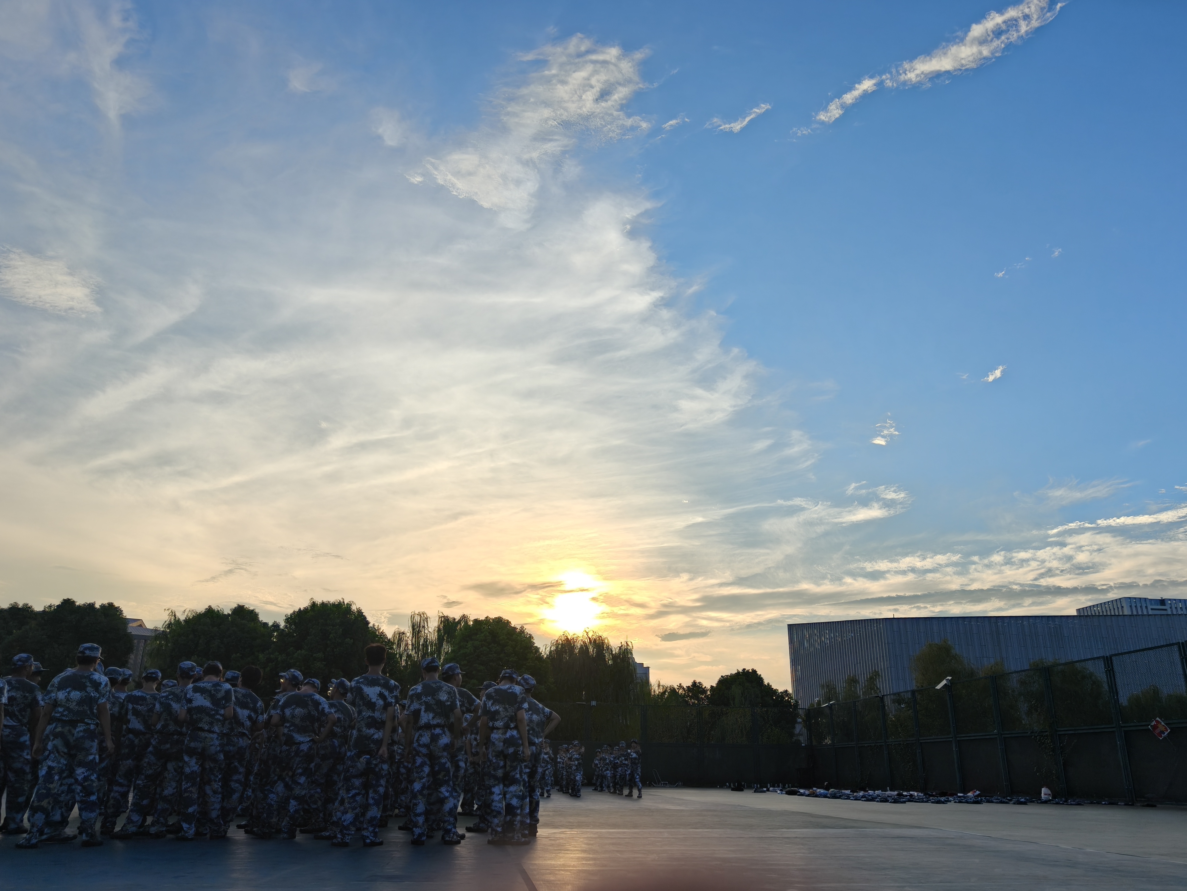 军训晚霞：军训尾声，落日为少年们镀上了一层暖调，裹住了少年们流出的汗水。