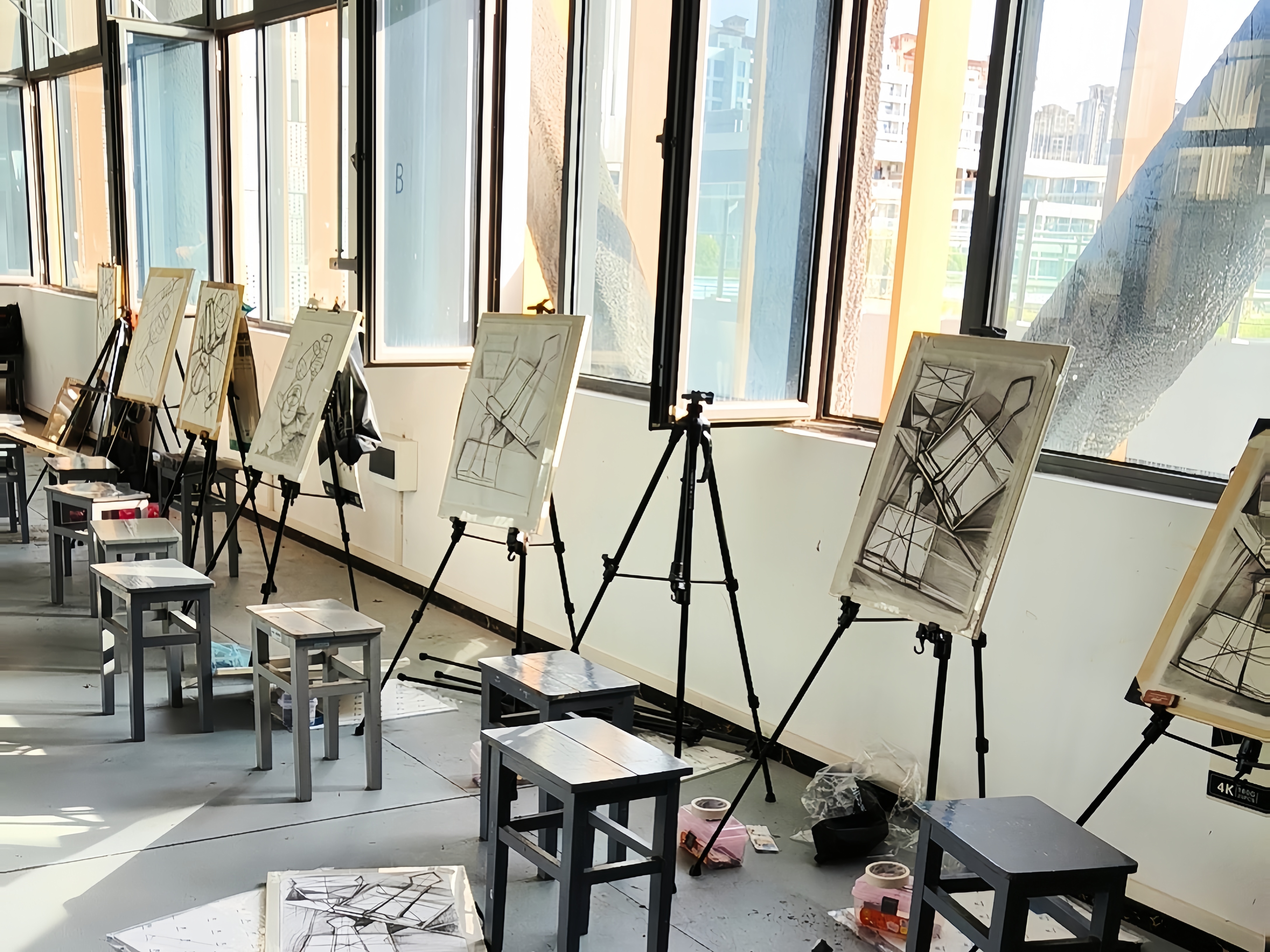 画室一角：早八的教室里，画架旁边叠着光影，炭笔在纸面上摩挲出线条，此时此刻，阳光正好。