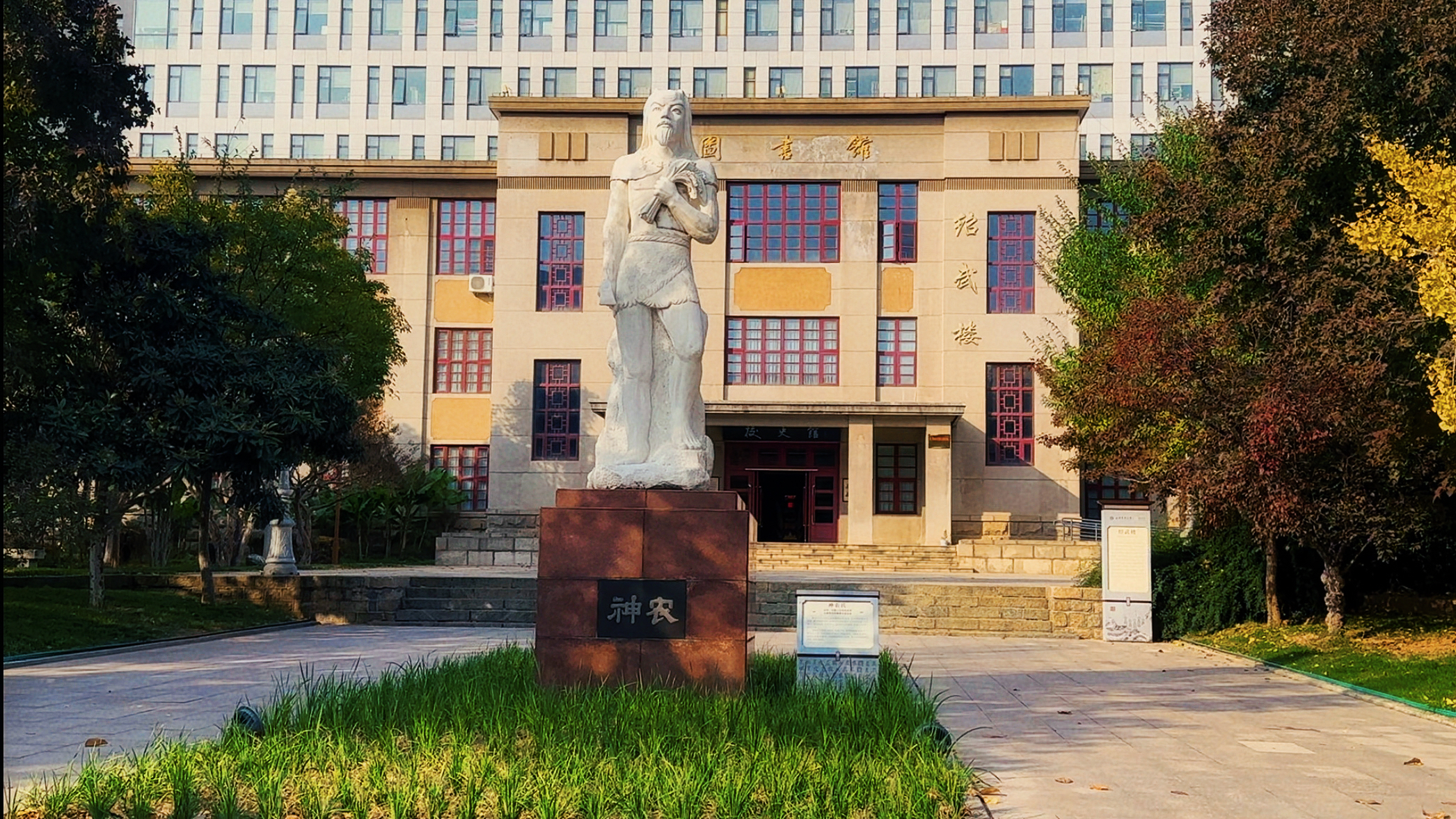 图三：神农与图书馆——传承里的精神力量
神农沐光映经武楼，尝百草勇气与馆藏书香相融，是农科学子传承的精神养分。