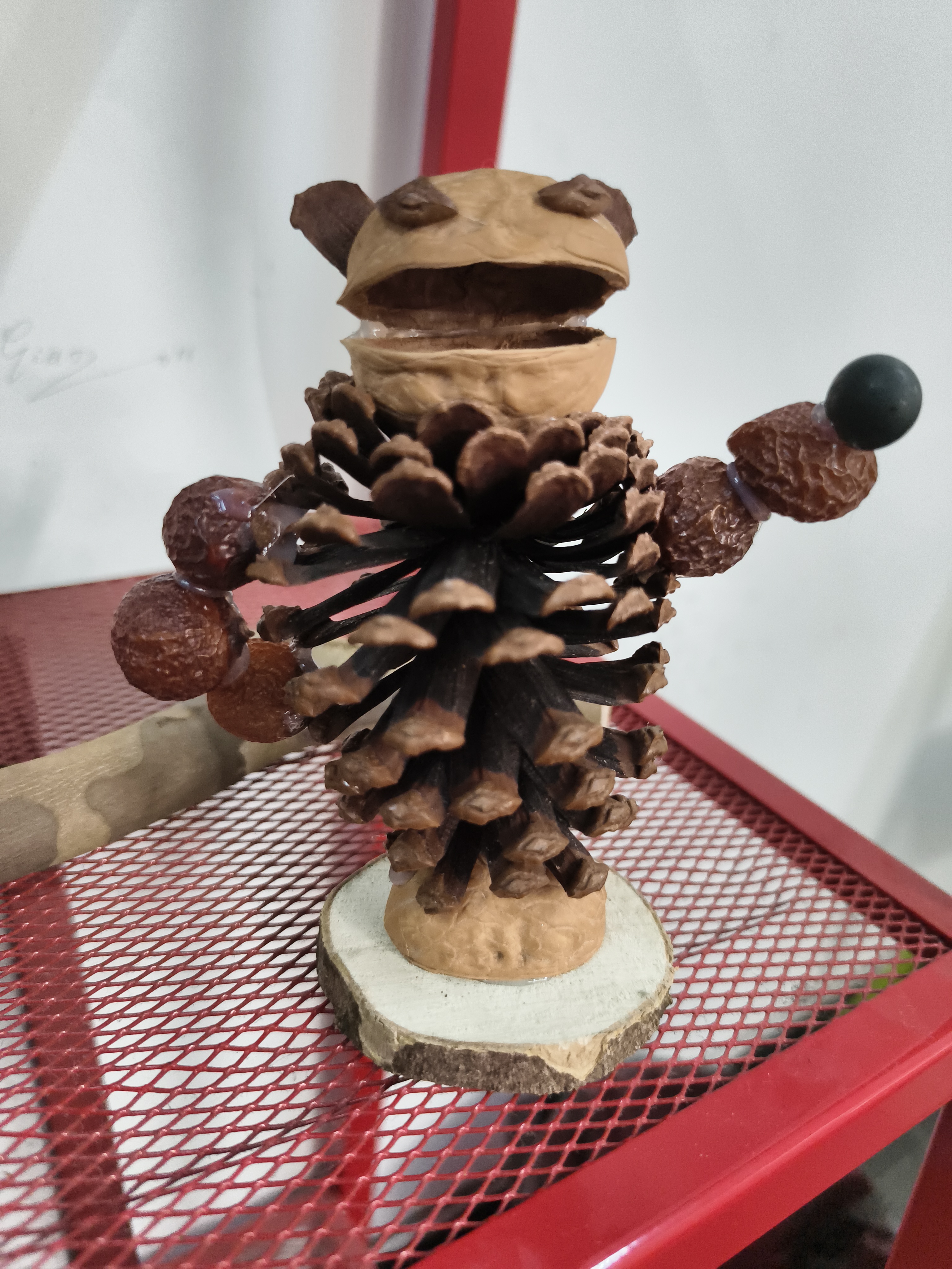 这是松果版本的石矶娘娘，松果为身体，野枣作为手臂，用胶水固定嘴巴的形状，憨态可掬，富有生命力。