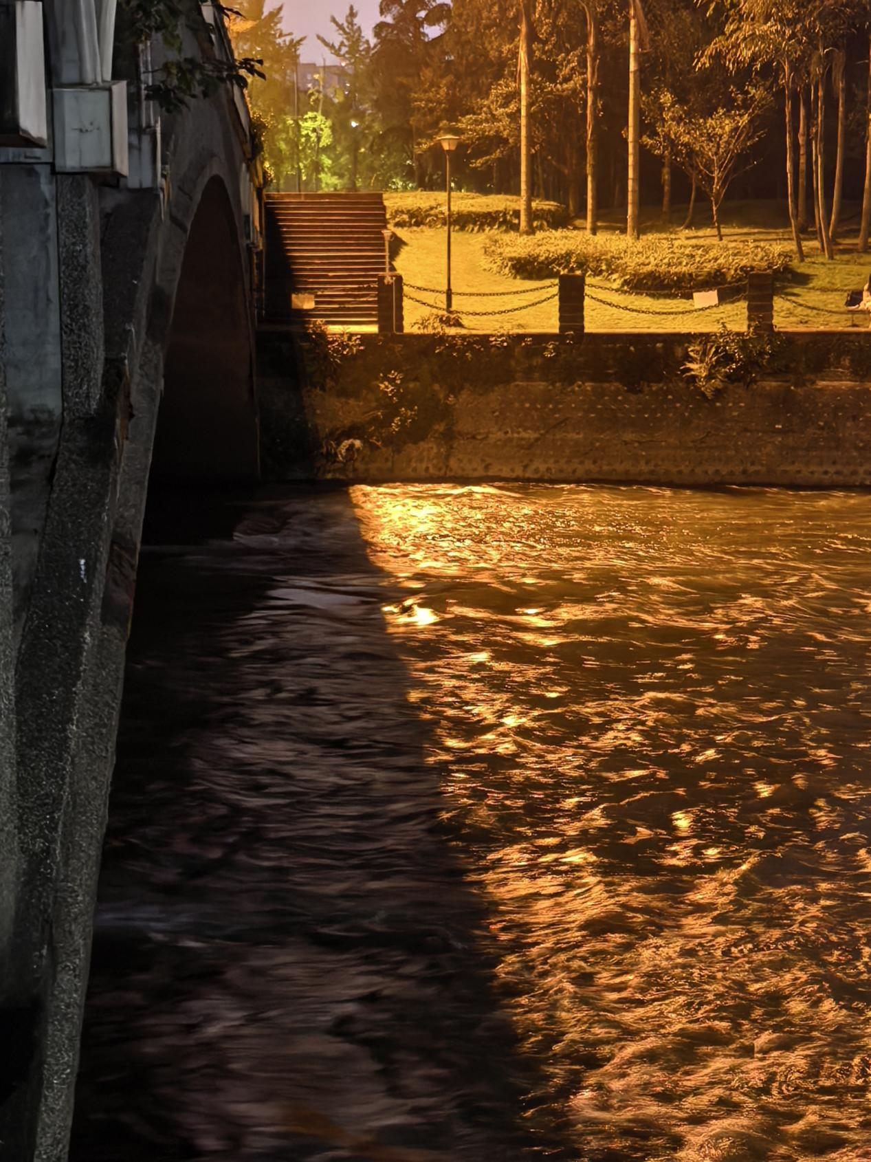 灯光避开桥面，在水面晕开圈圈金芒，天上的星星全被揉碎撒下。秋冬的夜虽凉，可这束光却暖得刚好。