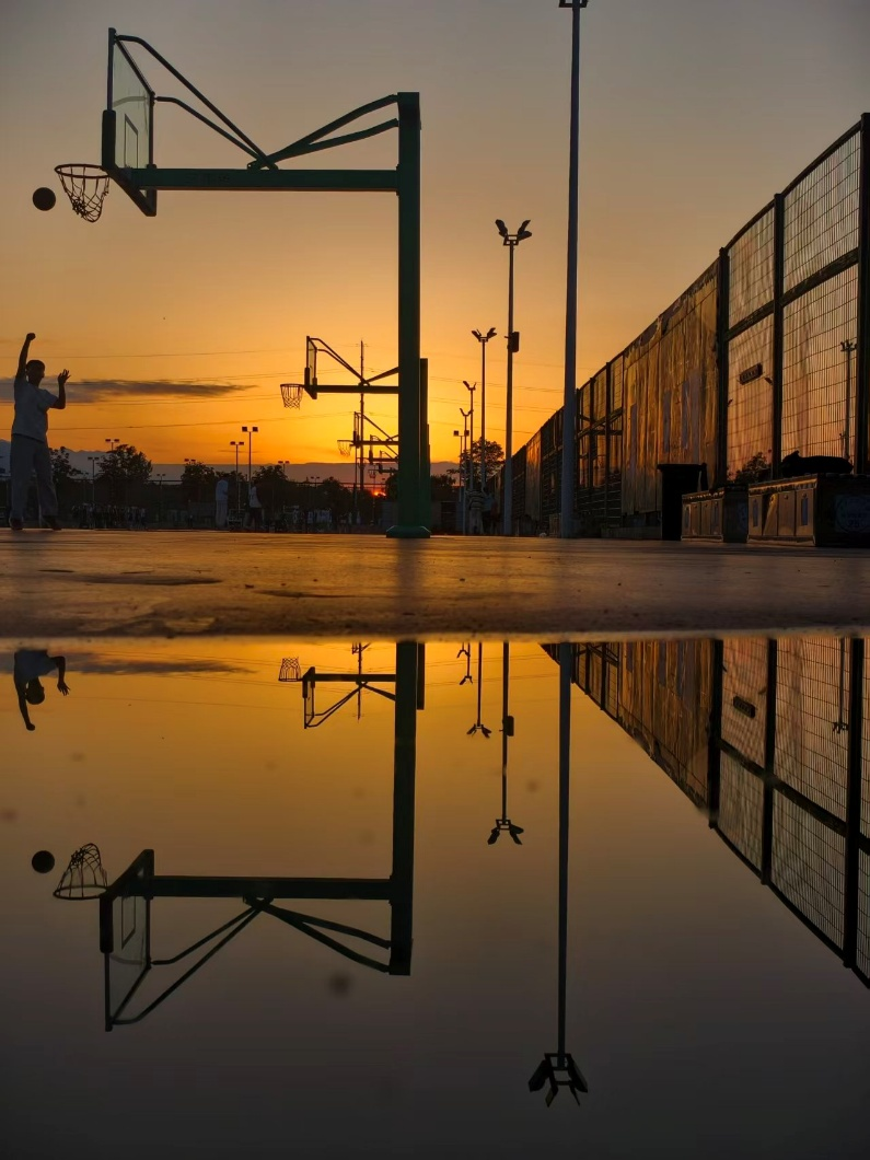 彩秋当然不只有景色，还有彩色的青春，美好的青春。路过篮球场，一人正在上篮，夕阳西下，正好拍到篮球与夕阳，也是独特的美。