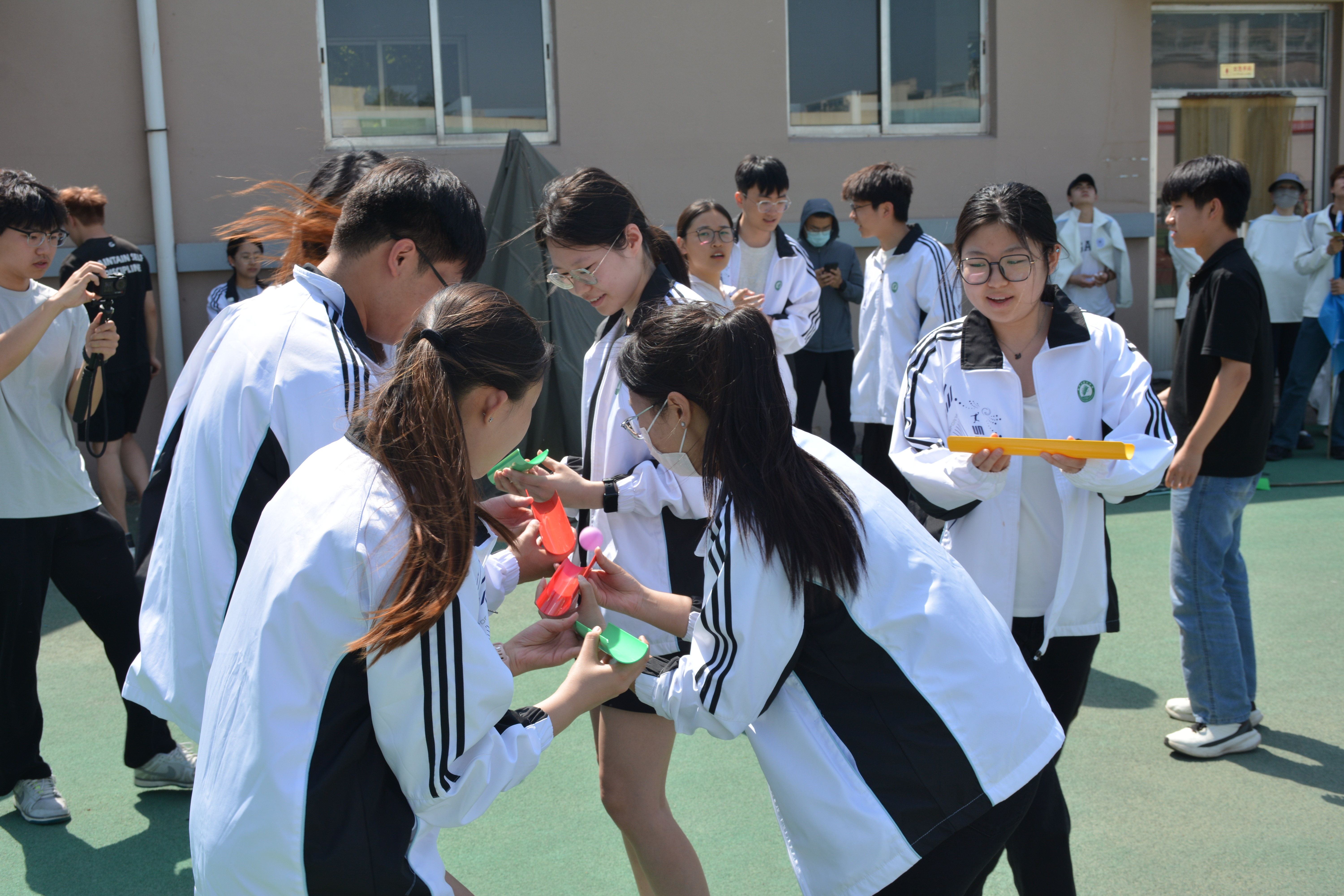  团建游戏时同学们默契配合、通力协作，在趣味比拼中增强专注力与团队凝聚力