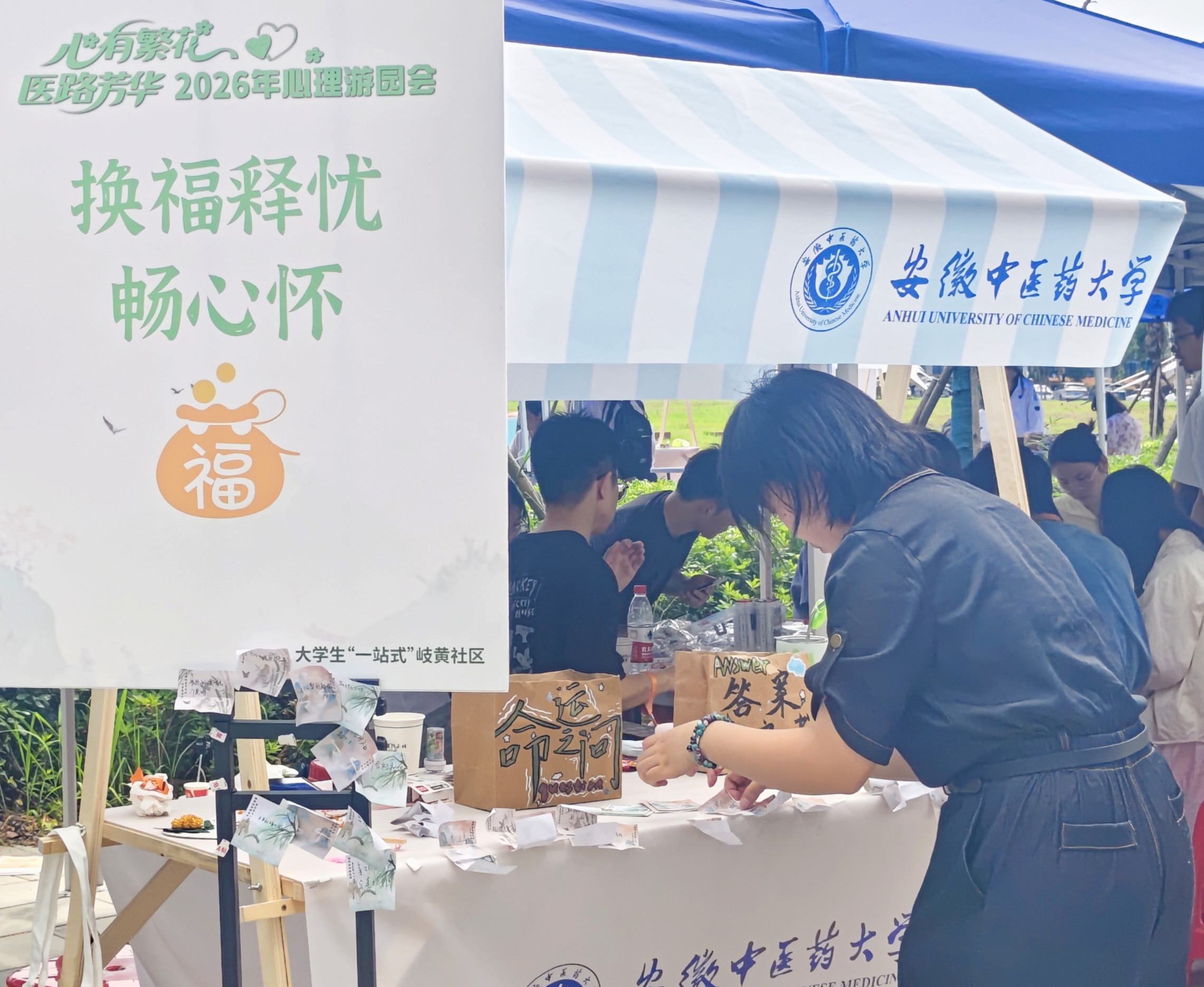 图为工作人员正在“换福释忧，畅心怀”摊位收集整理交换福签。
