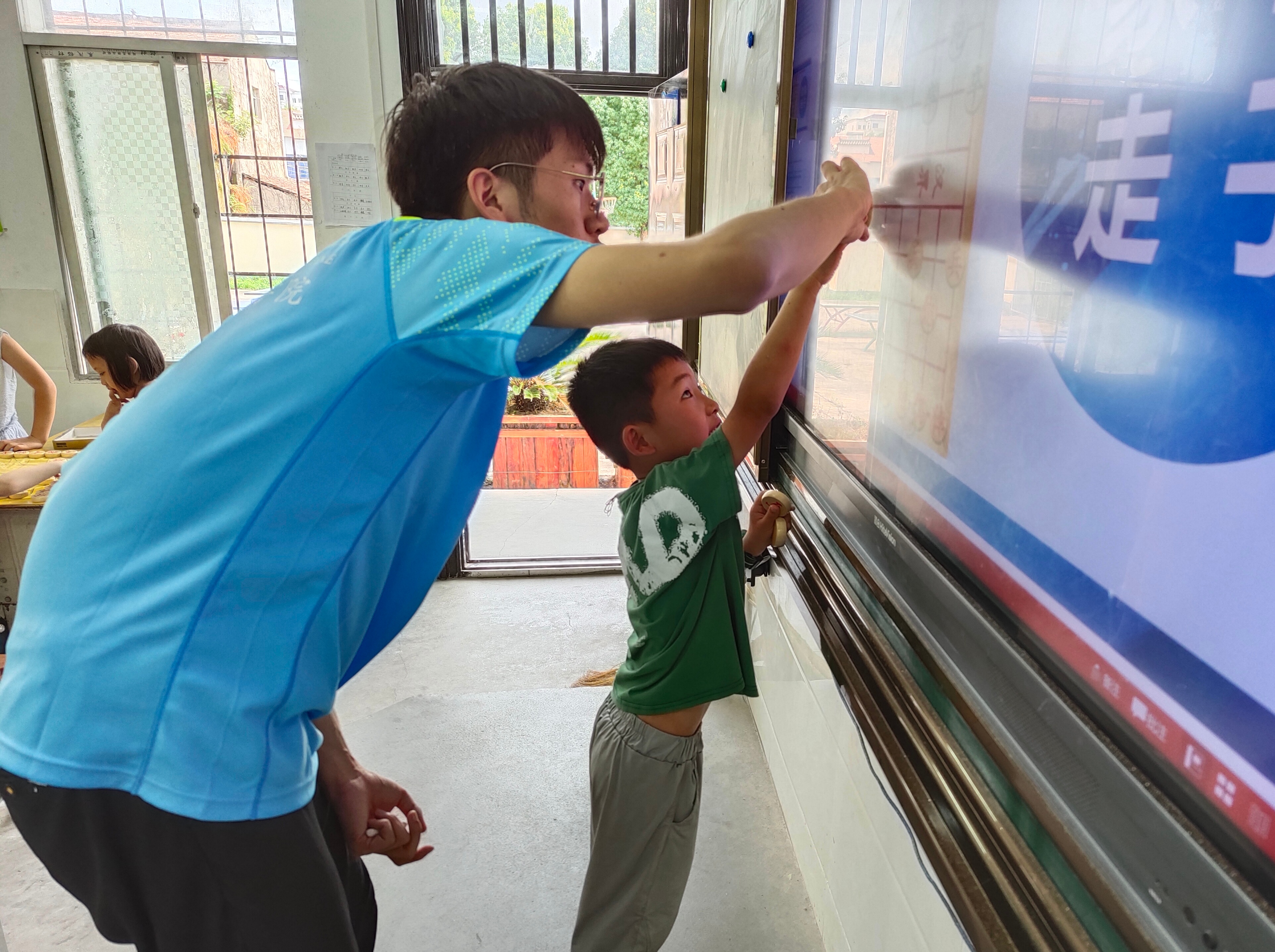 ﻿﻿图为实践队队员郭旭给二年级小朋友教授趣味象棋课堂并亲自上手示范中国象棋基本走法时的场景。通讯员 王田美子 供图