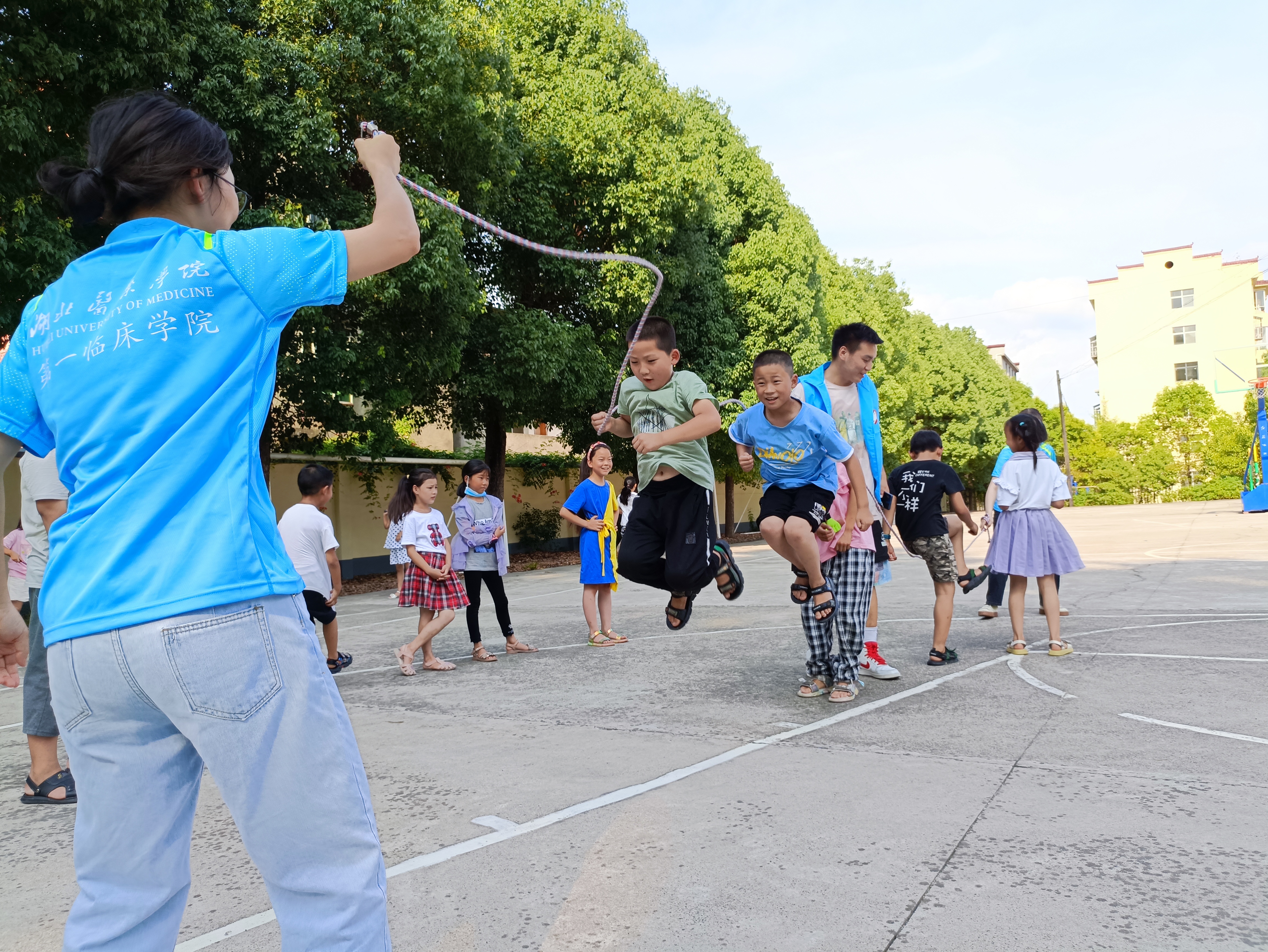 1313图为体育课堂上志愿者老师们和四,五年级学生开展跳绳运动时