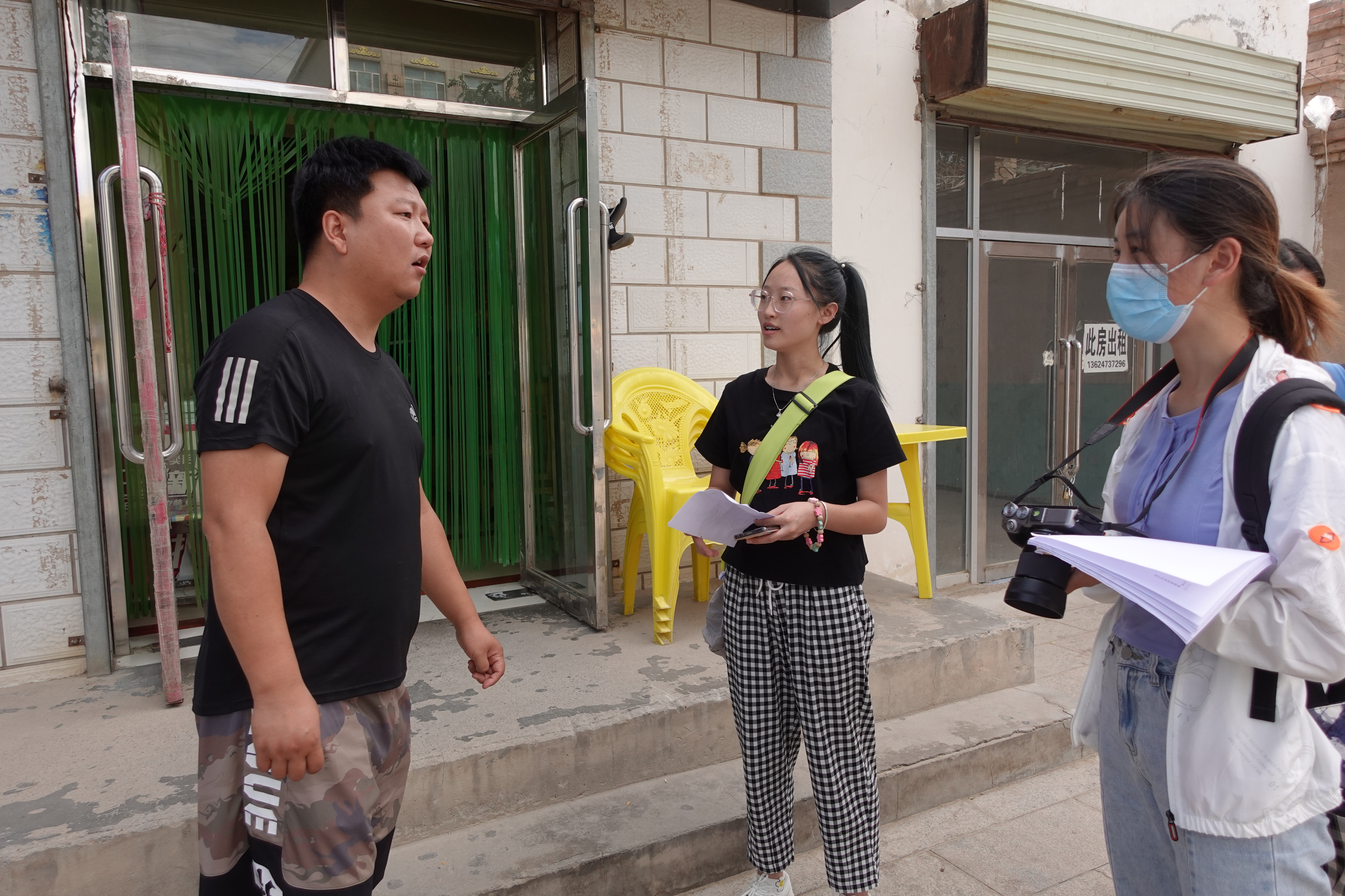 图为队员走访当地居民，向当地居民分发问卷，调查生态环境对群众生产生活的影响。