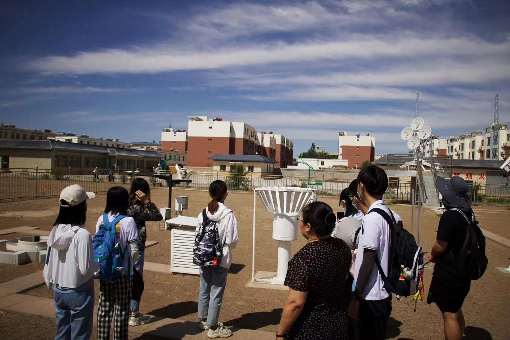 图为队员参观当地气象局，与气象局领导专家对近年来生态环境工作要点难点进行交流，并探讨了额济纳未来的发展规划。