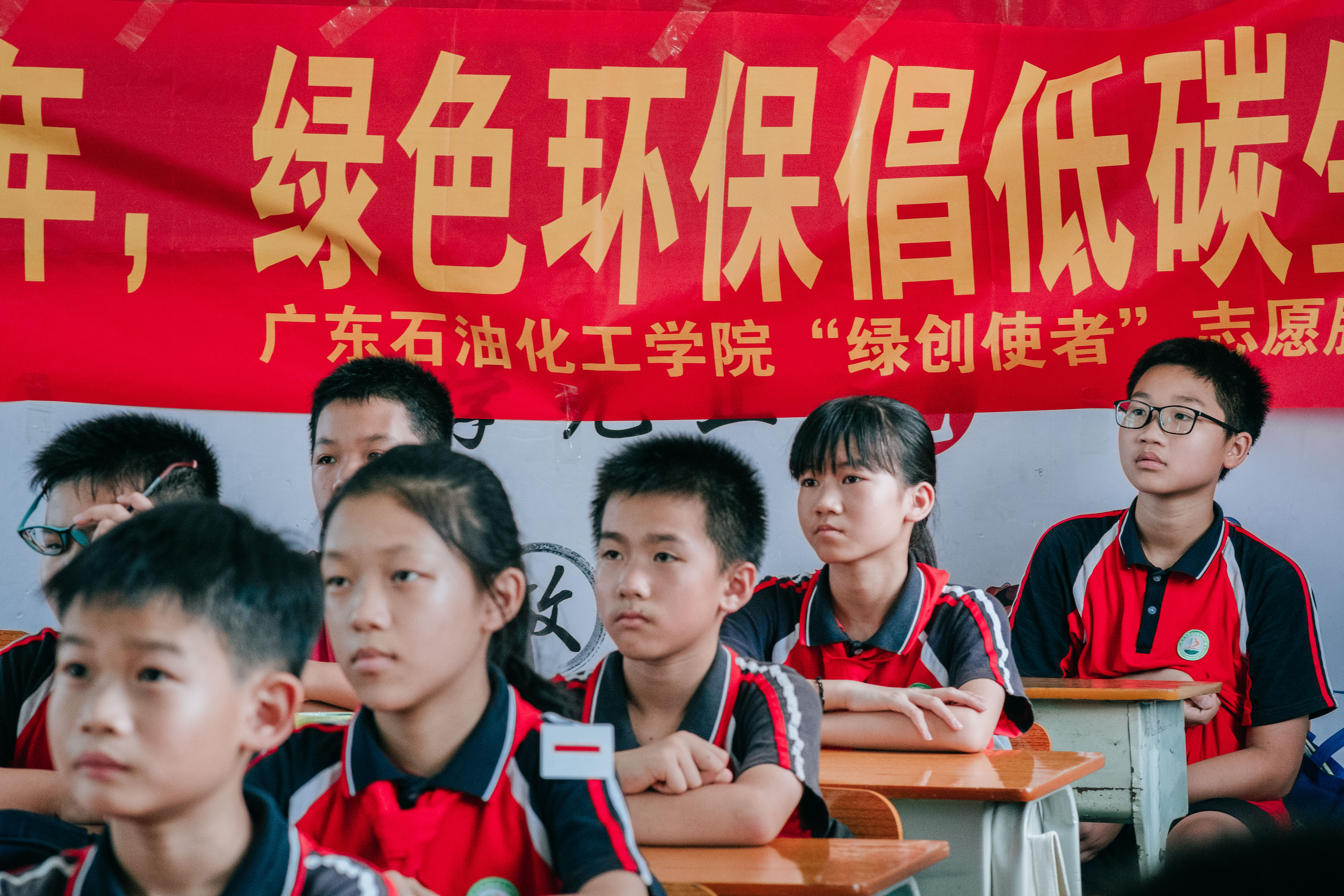 图为广东石油化工学院“绿创使者”志愿服务团队给露天矿小学学生上课时，学生们在认真听课。