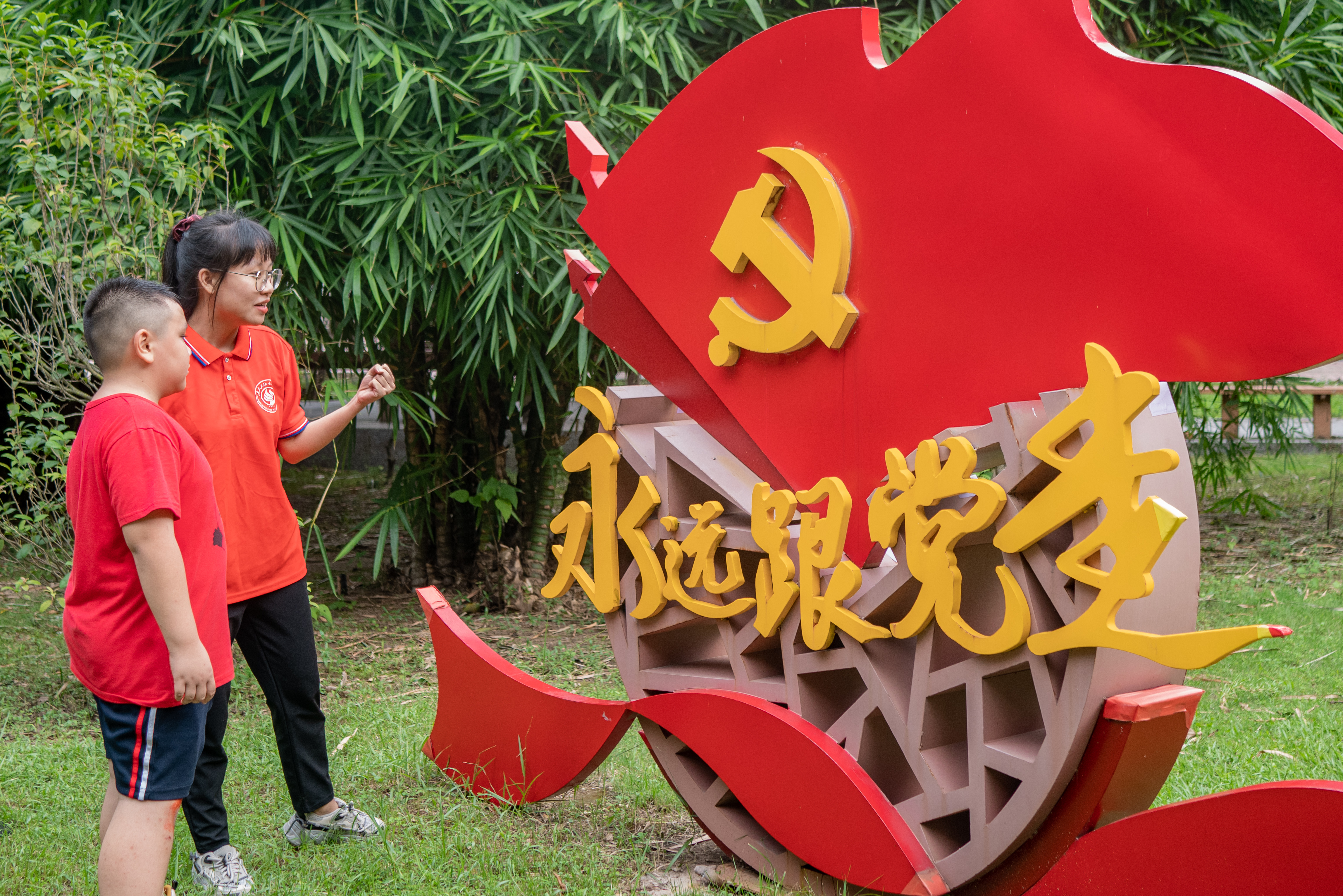 图为广东石油化工学院“绿创使者”志愿服务团队给学生讲述党员故事和党史小知识，旨在增加学生的爱国情怀和坚定理想信念。