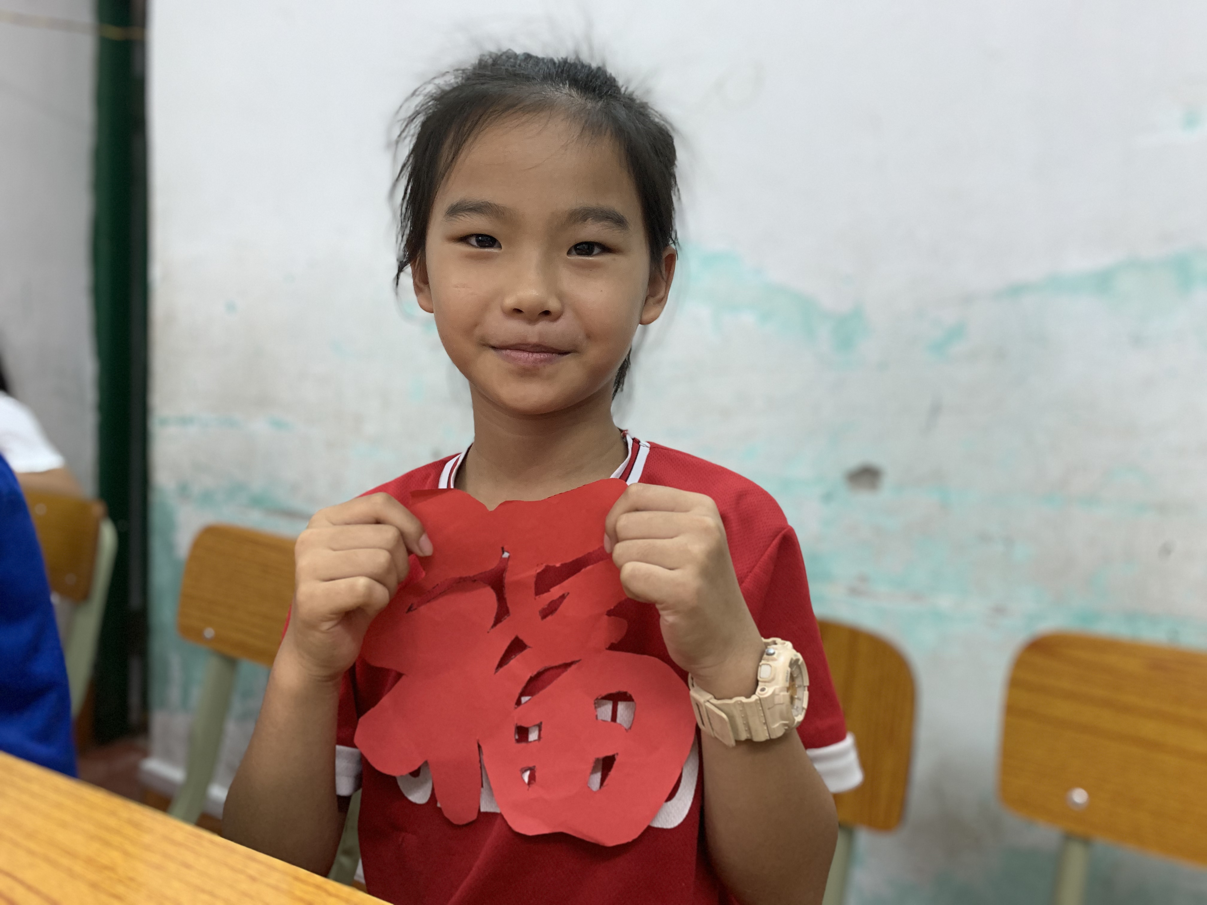 图为“绿创使者”志愿服务团队在露天矿社区里让学生展示剪纸课堂后的成果。