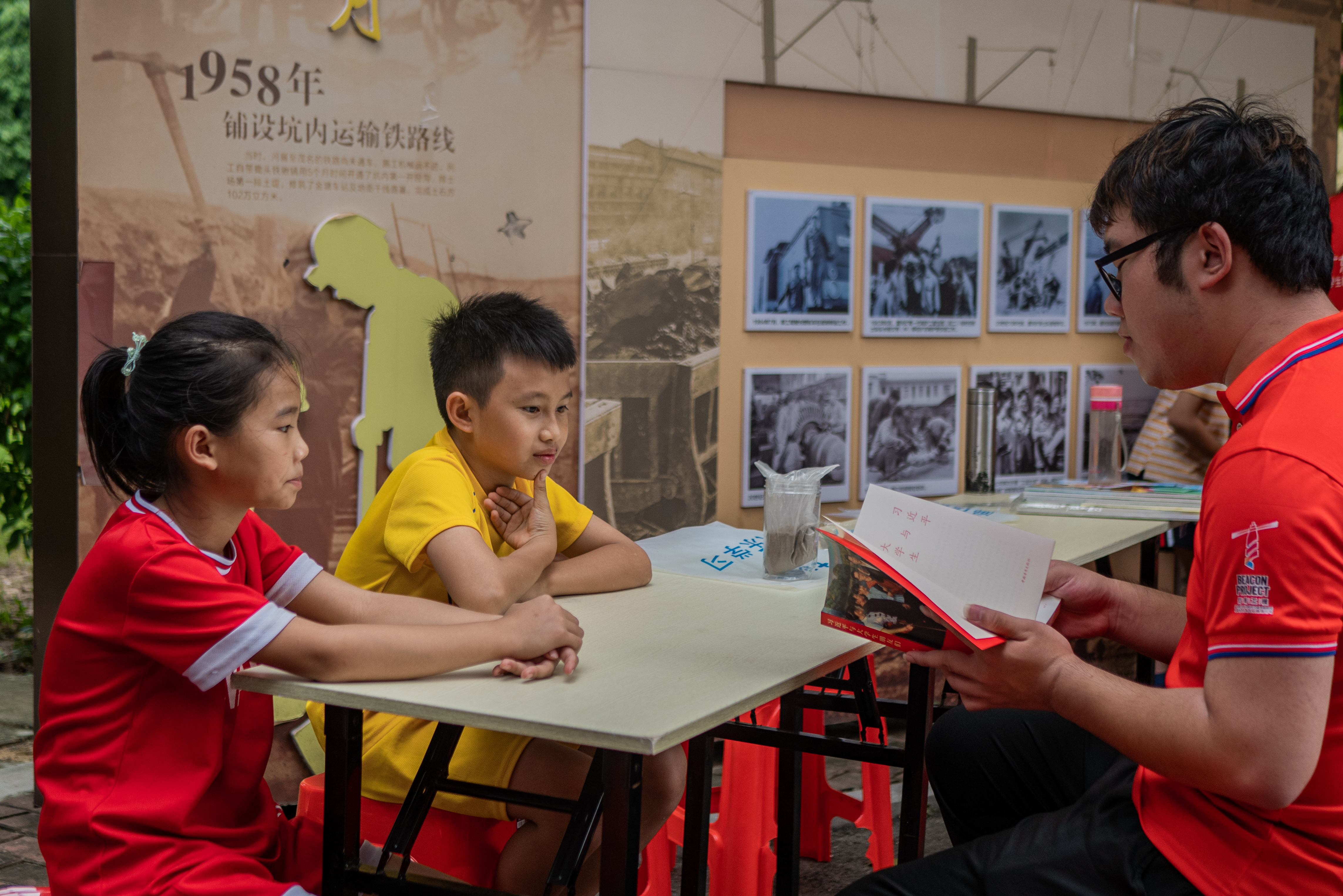 图为“绿创使者”志愿服务团队成员在社区给学生讲解《习近平与大学生朋友们》书籍，让学生们更了解新时代青年的使命。