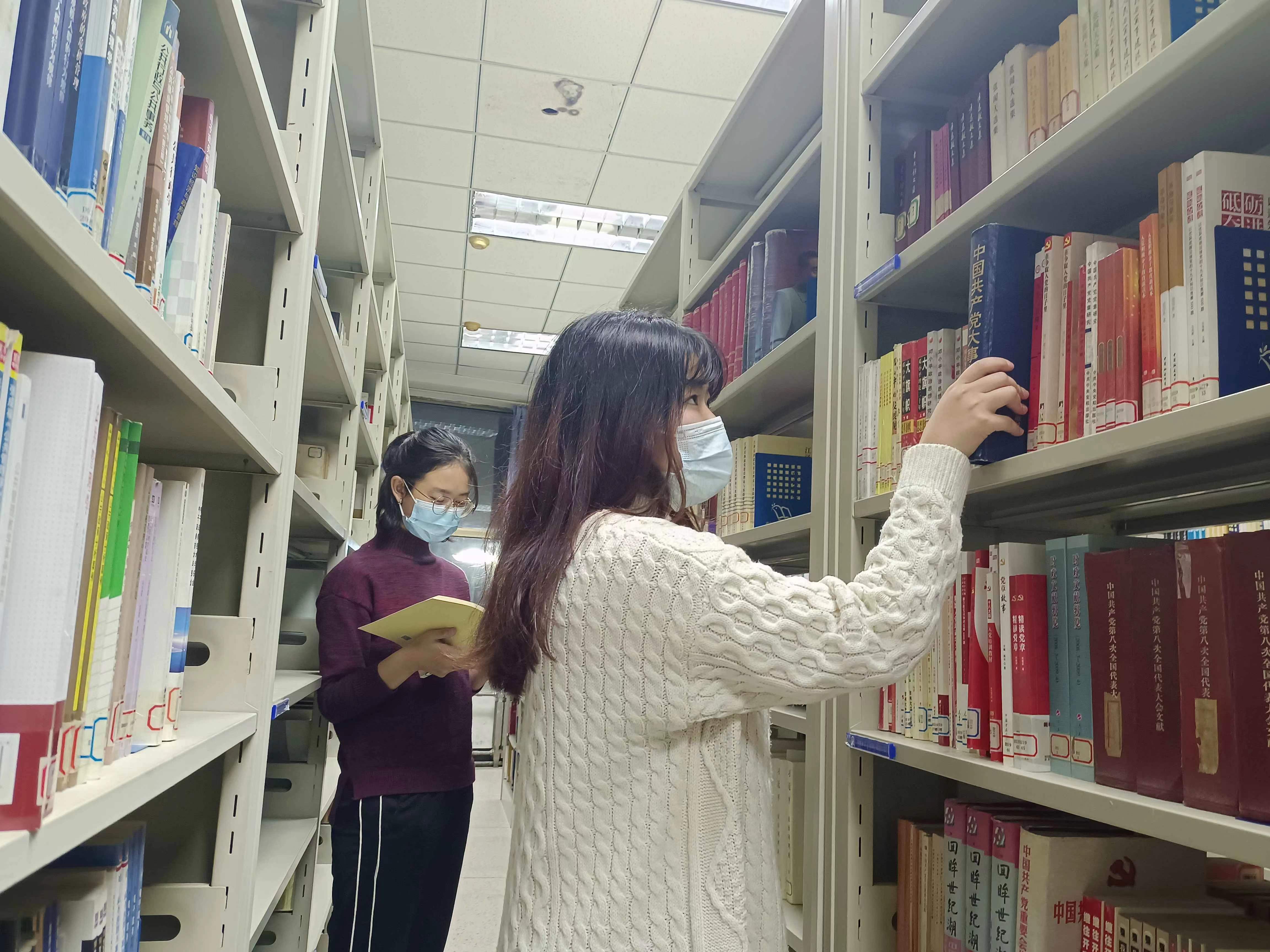 在溢满书香和智慧的图书馆中查找党史著作。