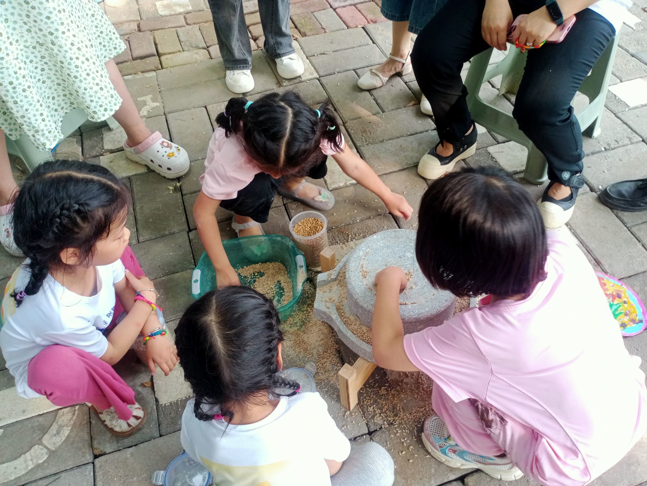 01 图为实践团成员拍摄的小朋友们在玩石磨 河南城建学院 钱梦男 提供