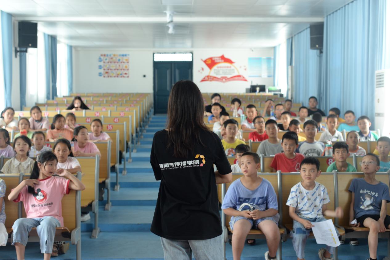 图为志愿者对钟宝镇小学学生们进行歌唱指导，为即将到来的文艺汇演做准备。通讯员 阎奕璇 供图