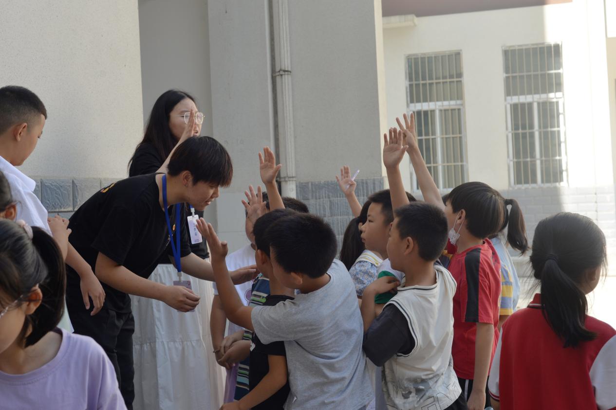 图为钟宝镇小学学生在课堂上举手回答志愿者的问题。通讯员 阎奕璇 供图