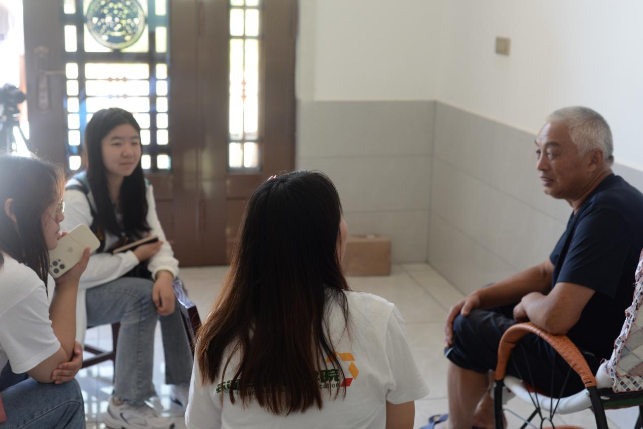 图为为了解民宿的开发与发展，实践团对钟宝镇第一期民宿经营者曾爷爷进行采访。通讯员 阎奕璇 供图