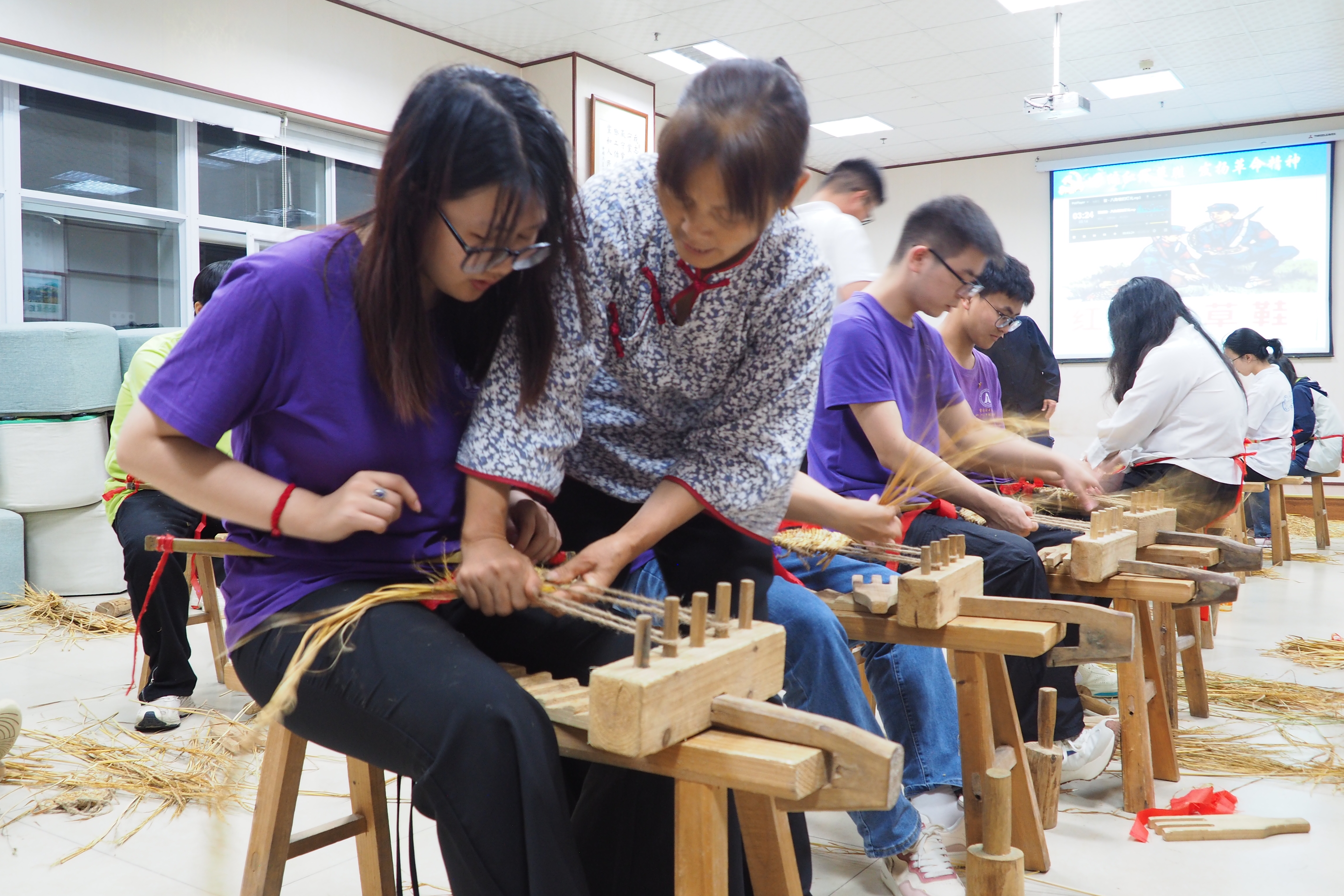 老师指导“两江新青年”数智赋能团成员编织草鞋