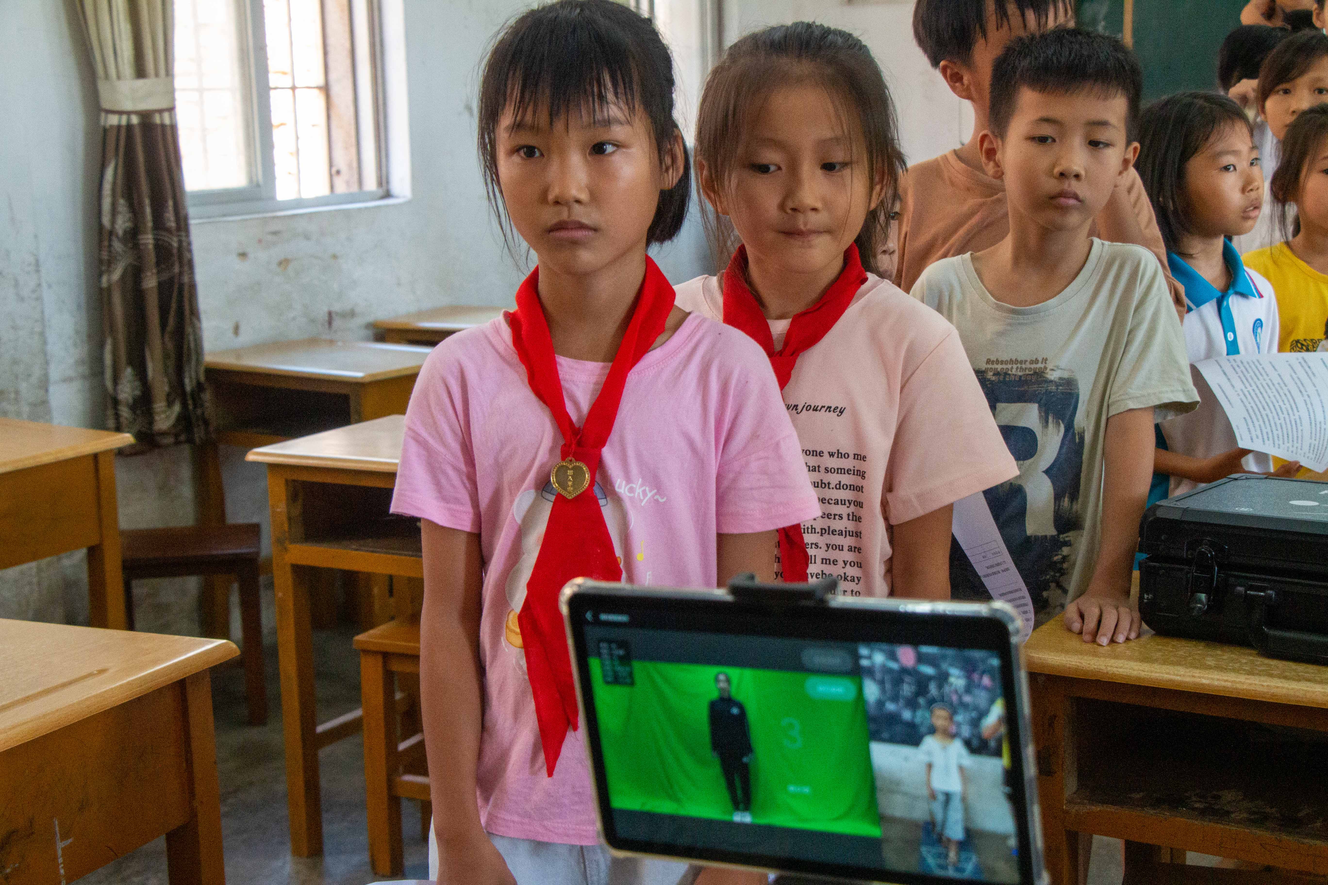 图为服务队队员利小朋友们排队进行脊柱侧弯筛查。 孙佳奇 供图