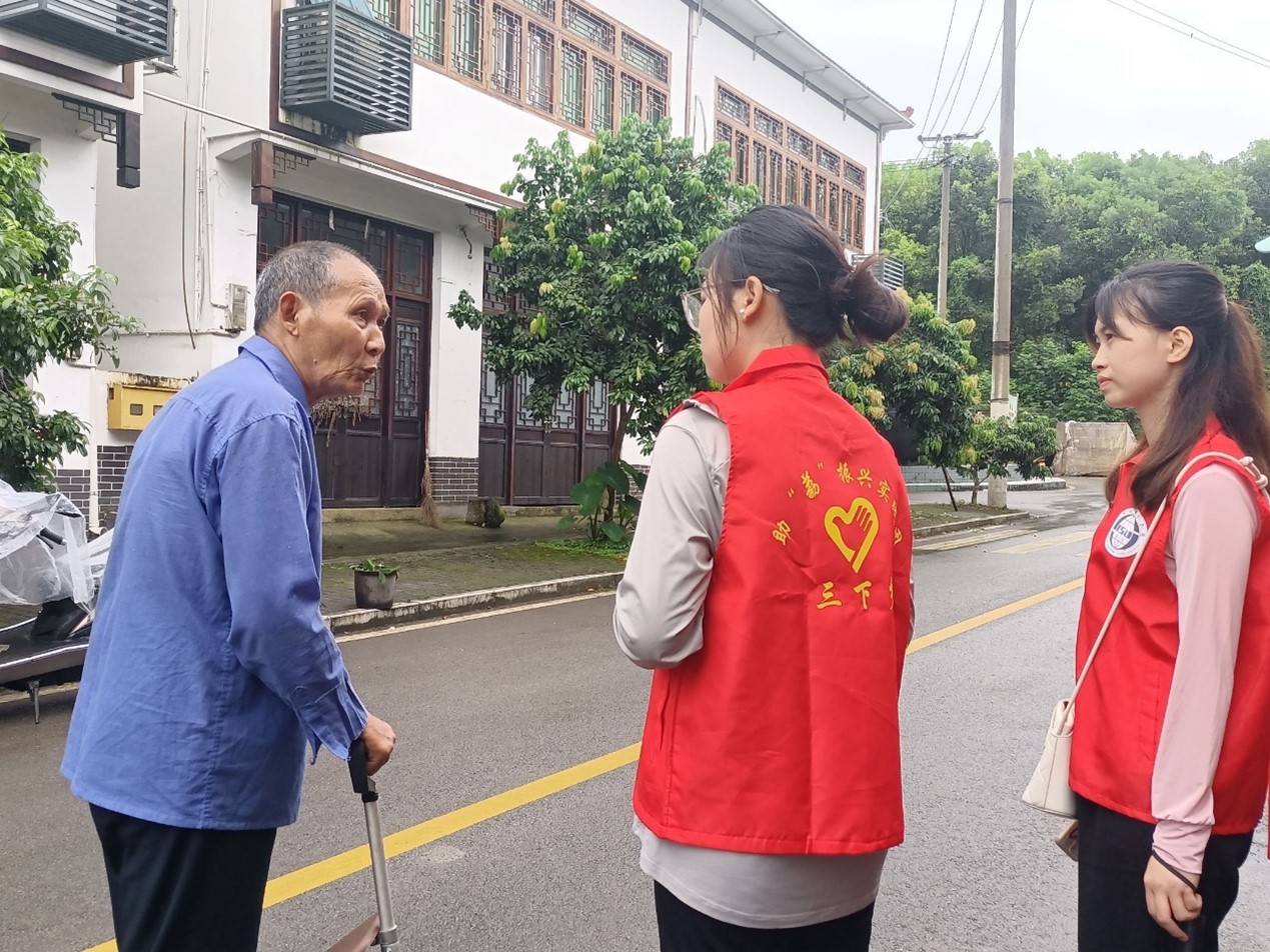 图为实践队员向当地农户了解当地政府对荔枝产业的政策。 李乐 摄