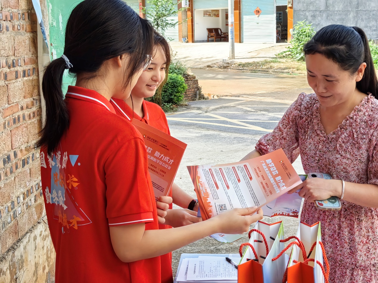 宣讲团耐心向村民介绍国家资助和助学贷款政策，并为村民解答相关问题。