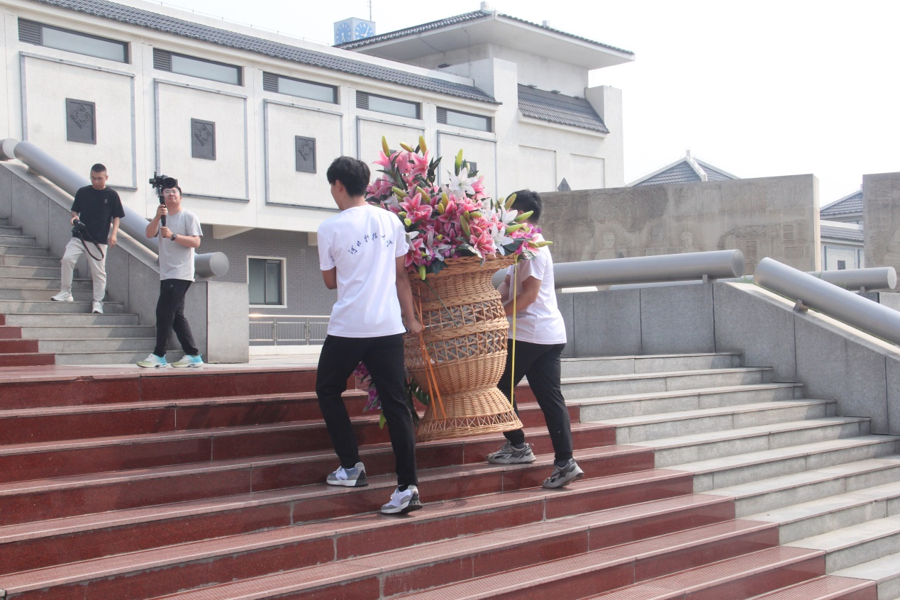 图为实践团成员在李大钊纪念馆帮助游客为李大钊先生敬献花篮 杨雅方摄