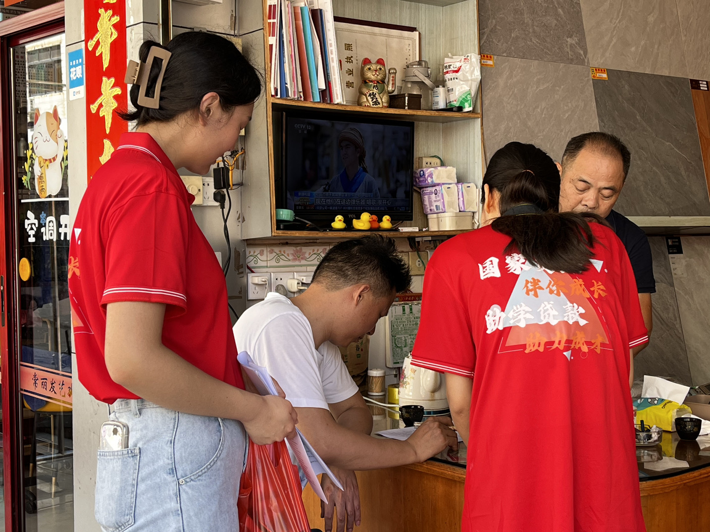 图为融媒体资助宣传实践队队员走访宣传资助政策现场。（林琳 供图）