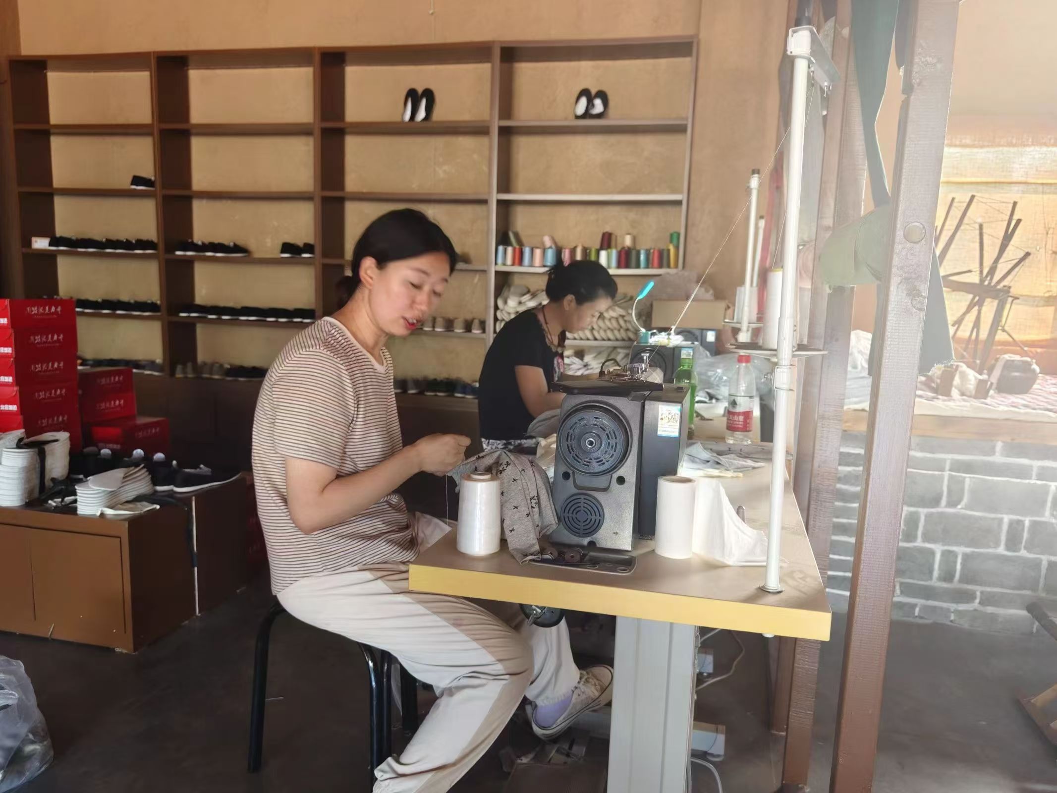 图为北庄村村民正熟练地使用新型缝纫机缝制衣物。谷雨 供图