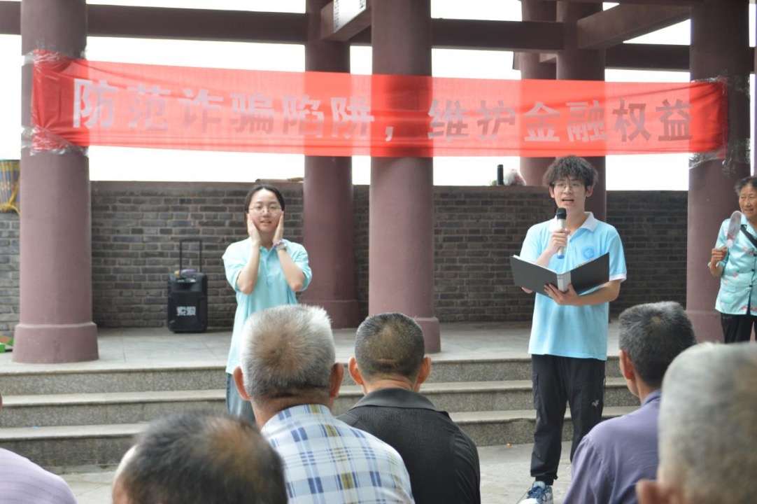 图为实践团成员向居民展示“AI换脸诈骗”的防范技巧。