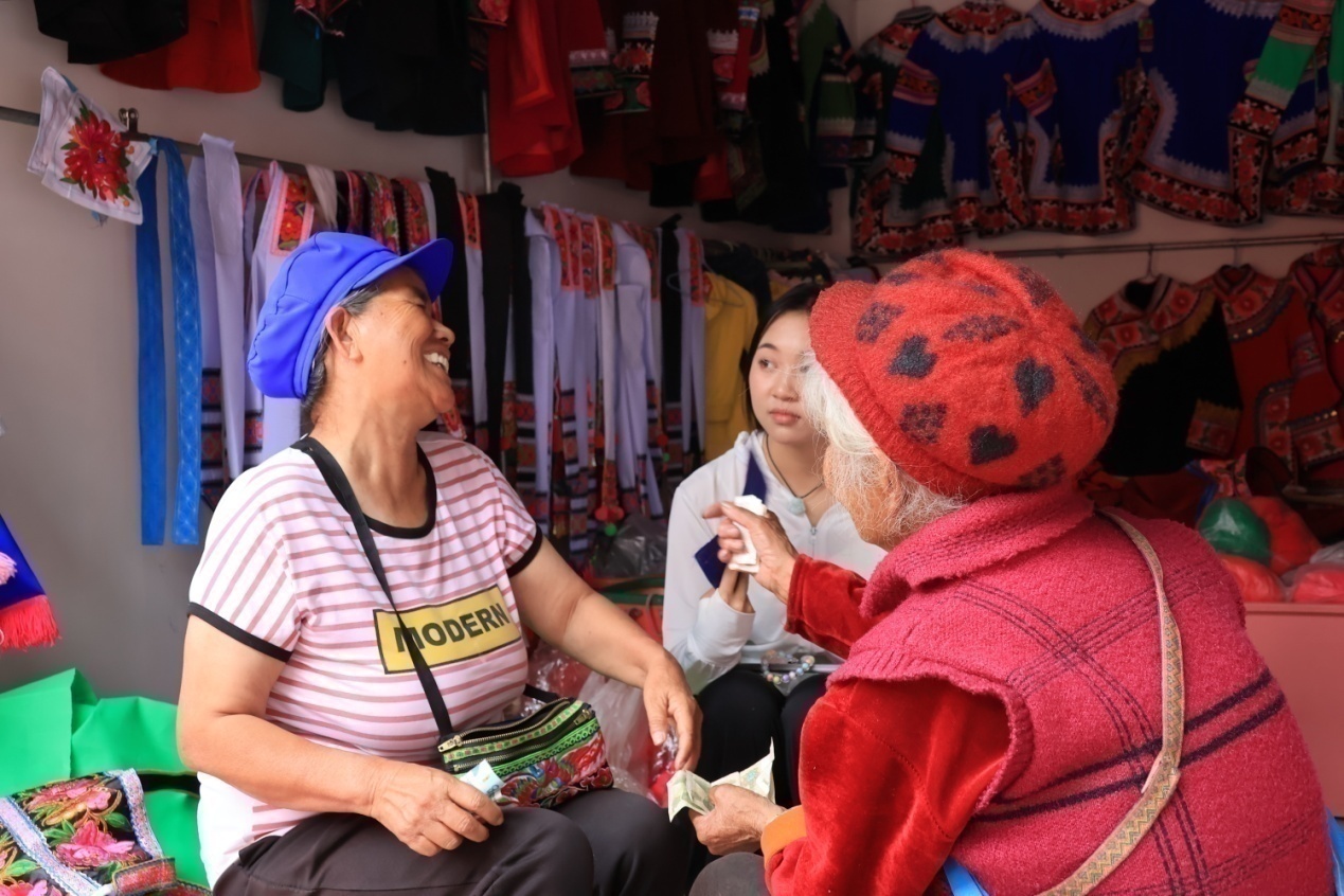 在 彝族服饰店  与老板交流分享自己与彝绣的故事  杨婷 梁瑞珏供图