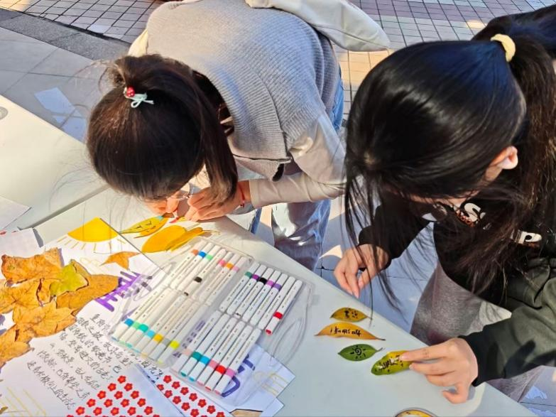“携秋贴画”大家用落叶替代心愿卡，写下专属秋日的小美好，合力填满秋日美景图