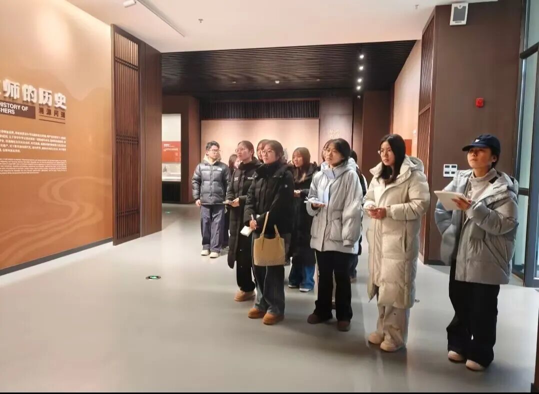 图为讲解员为实践队员讲解教师的历史.jpg