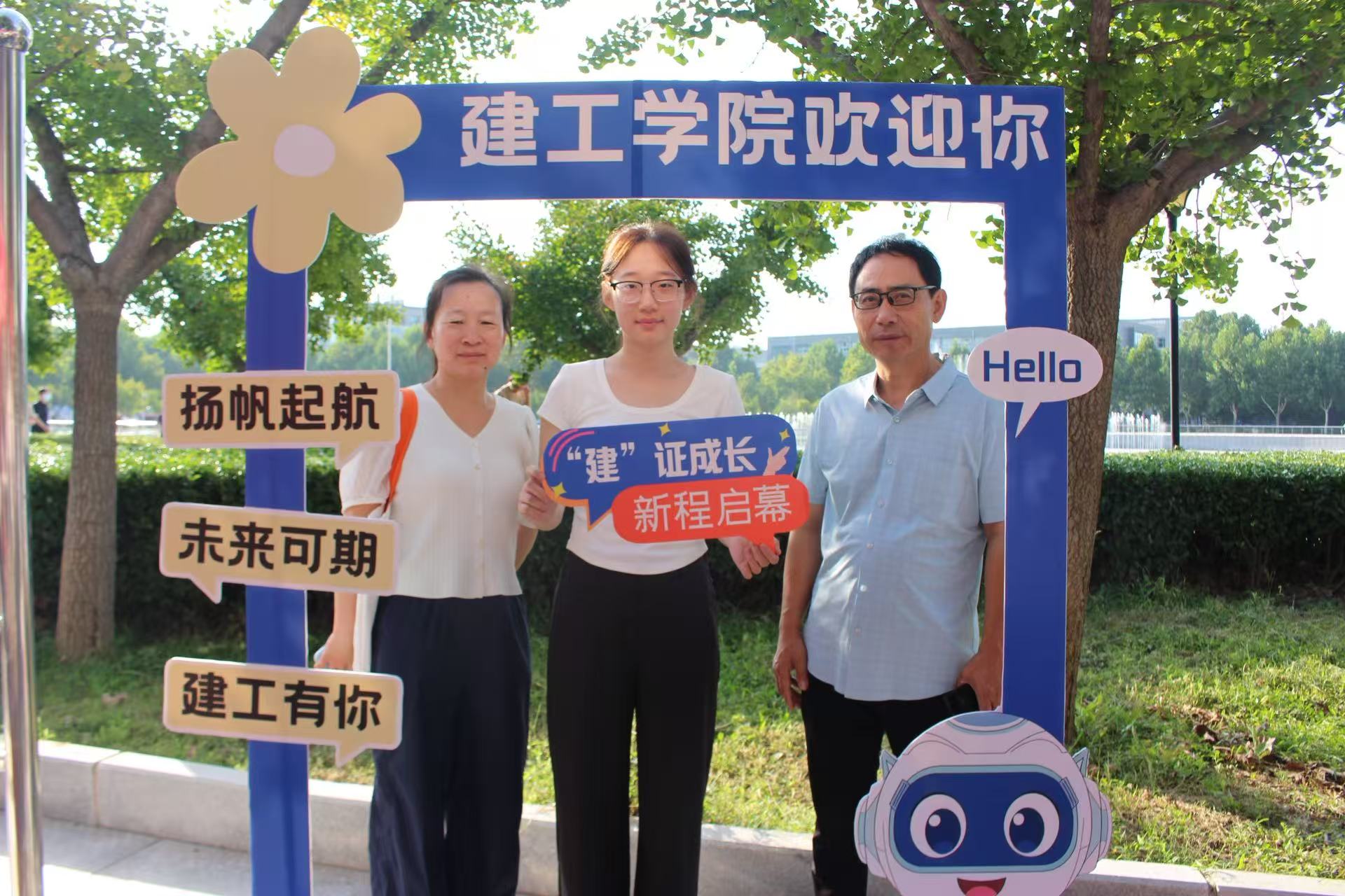 建工学院迎新现场，新生与家长在 “建工学院欢迎你” 主题打卡框前合影留念，定格入学美好瞬间