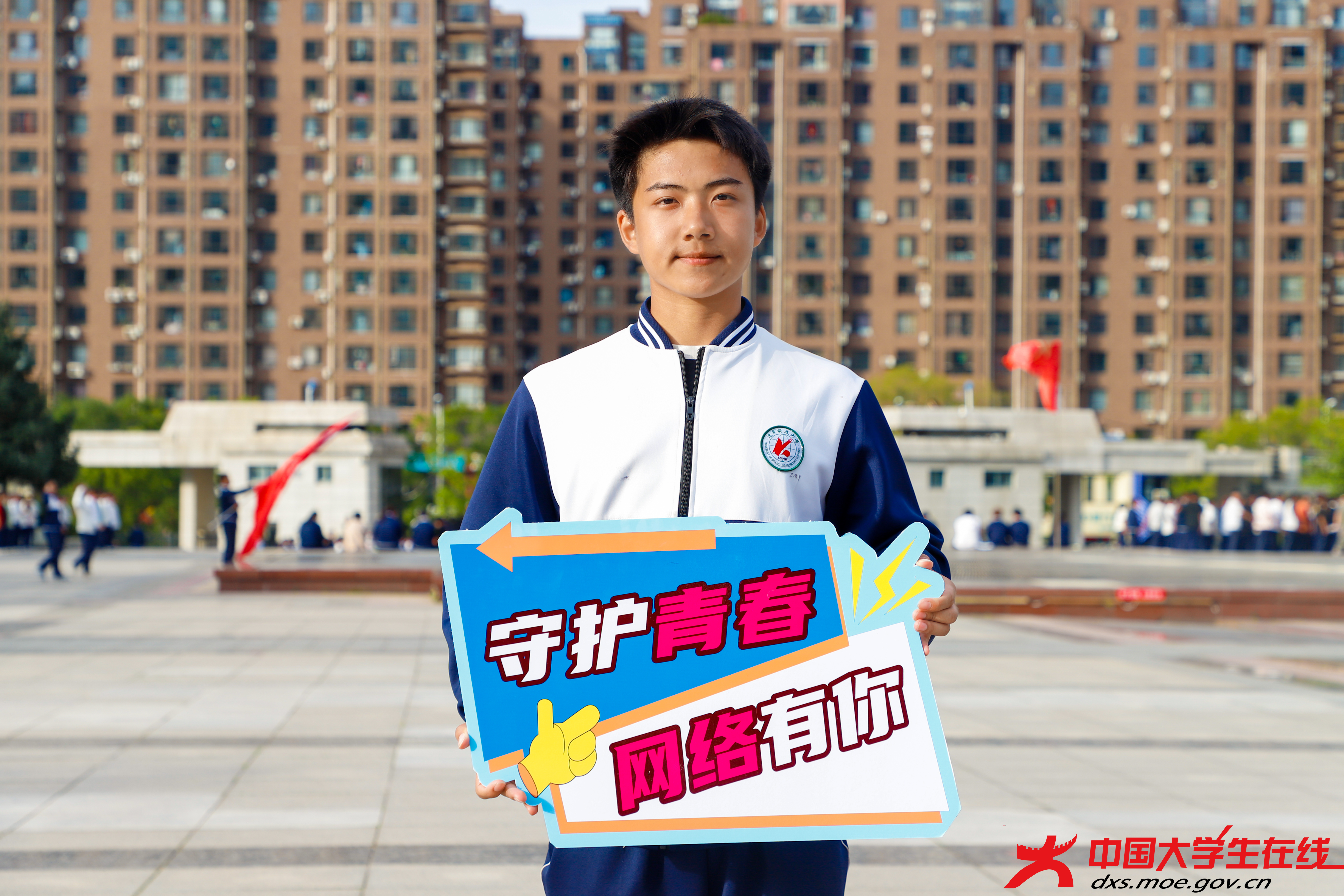 两位同学在居民区前呼吁，守护青春网络，你我共参与。