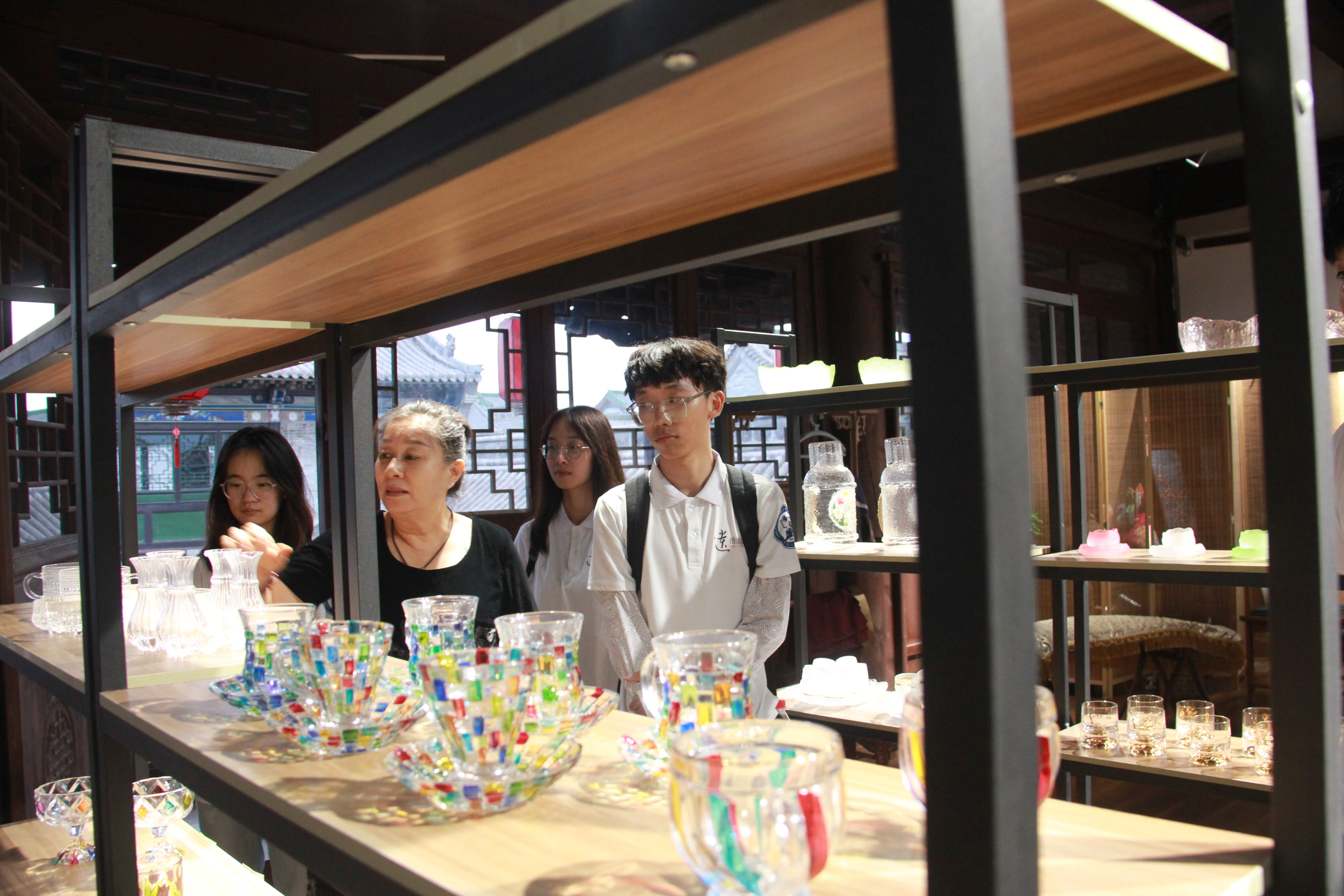 图为李西平女士向实践队员讲解菩铭屋非遗作品 周妩悦摄.JPG