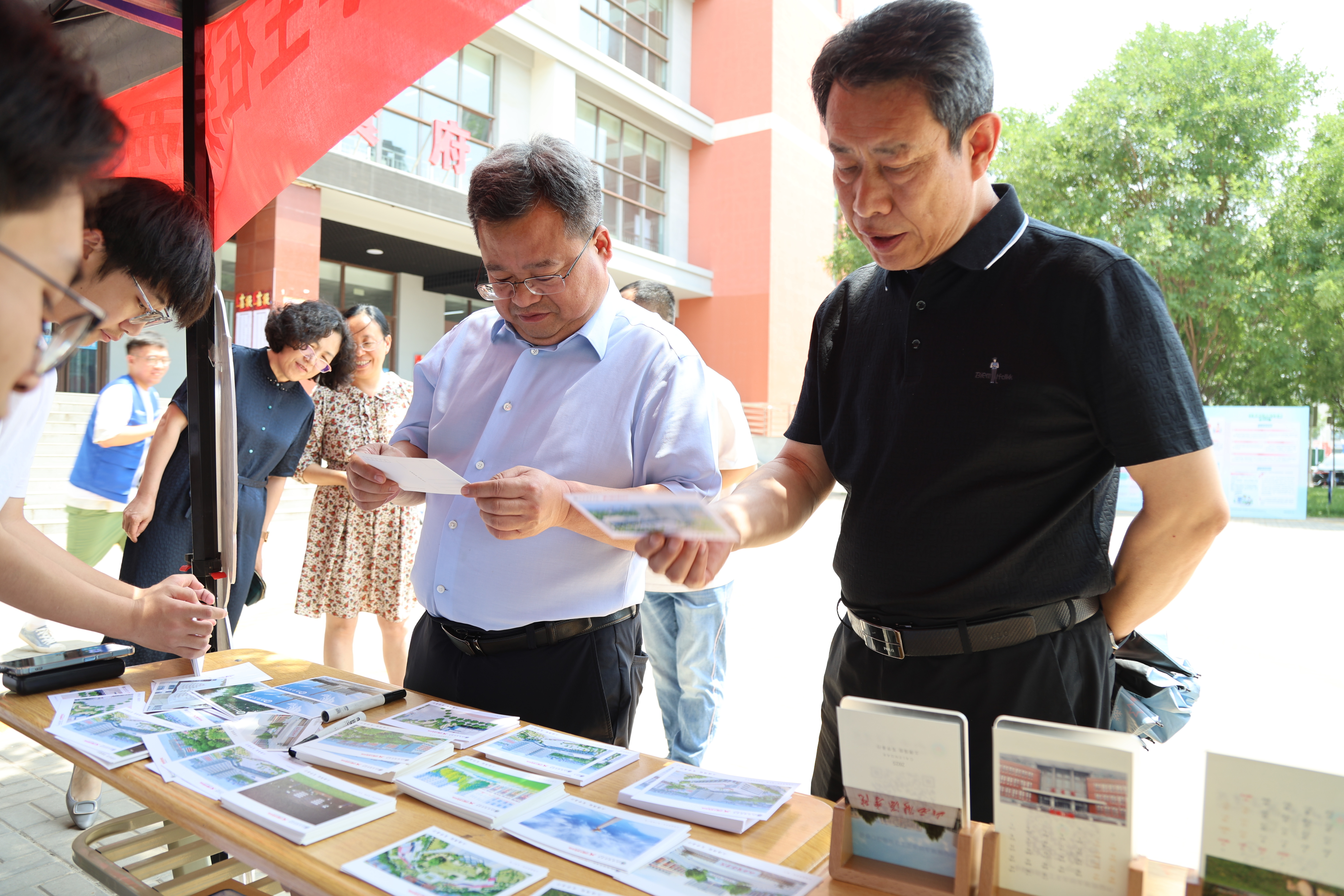 山西能源學院校黨委書記馮國瑞（左），校黨委副書記曲晉山（右）查看同學們自制明信片（山西能源學院地質測繪與工程系 賈靖銜 攝）