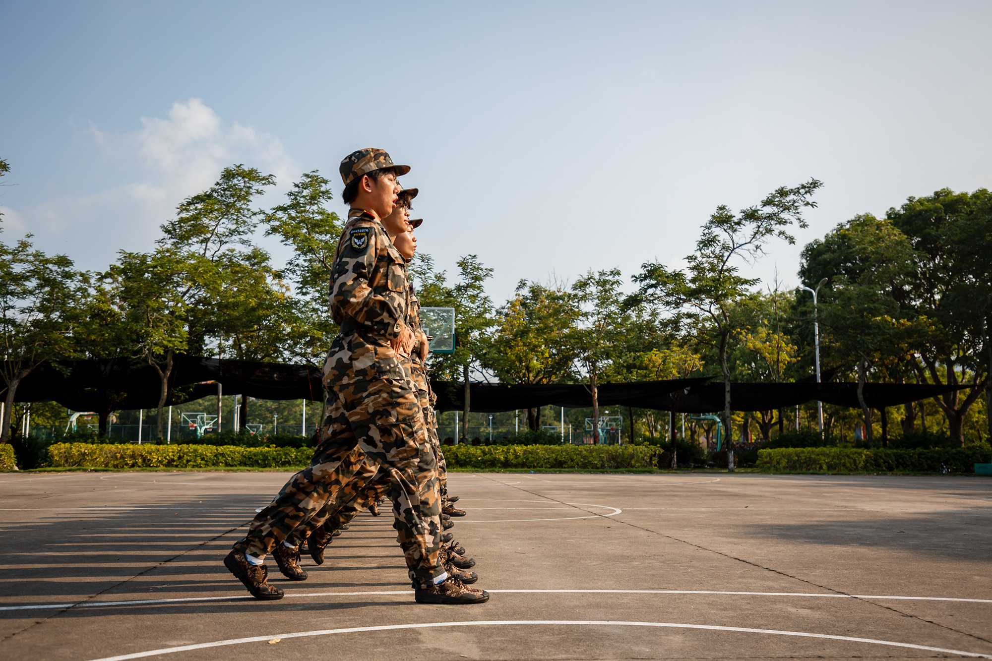 傍晚时分，夕阳如熔金般倾洒，将我们练习正步的身影拉长，投下一道道坚毅的轮廓。（摄影：朱鲜艳）