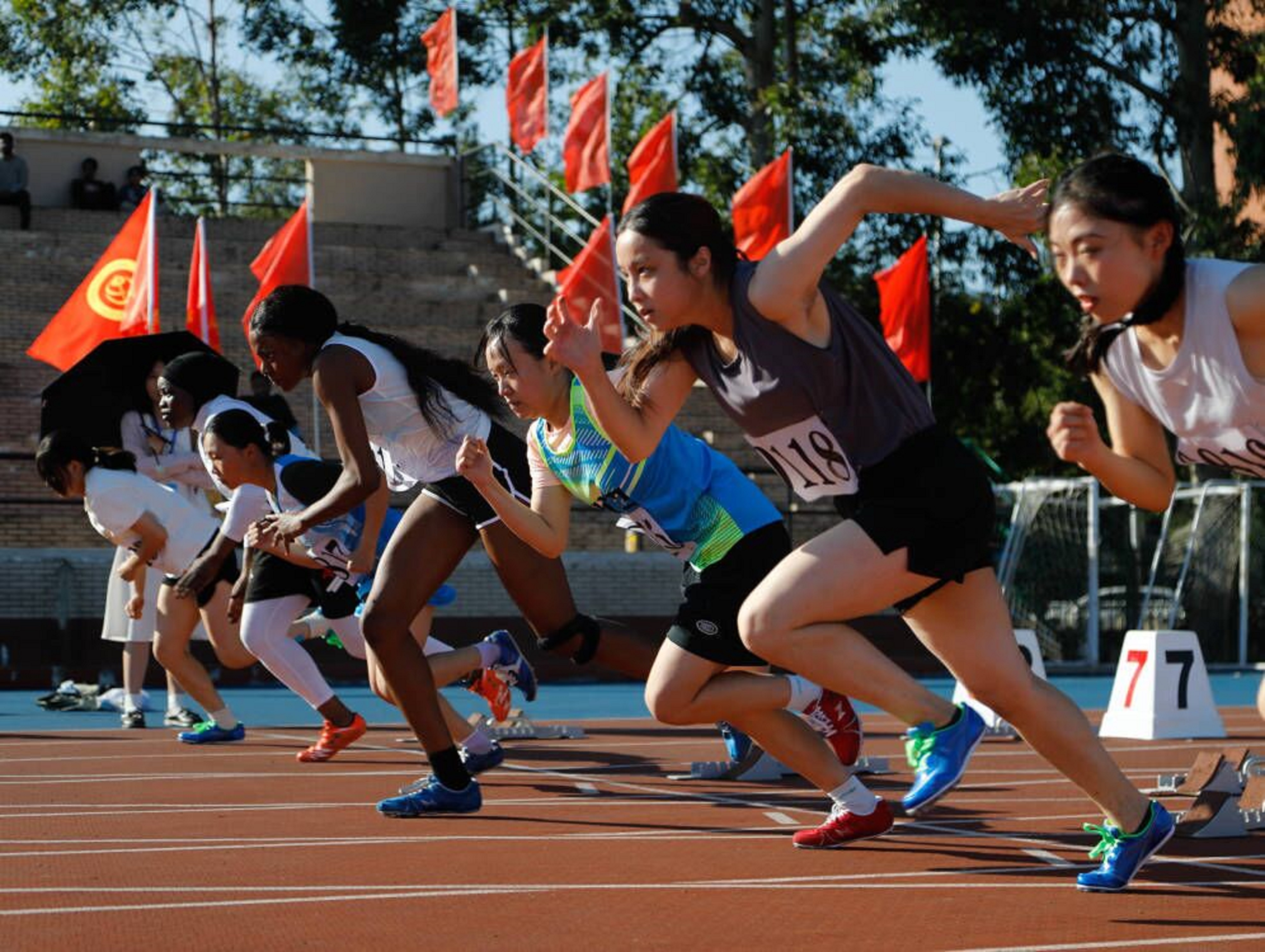 06图为女子100米决赛,运动员们蓄势待发,奋力冲出.吴波言 摄