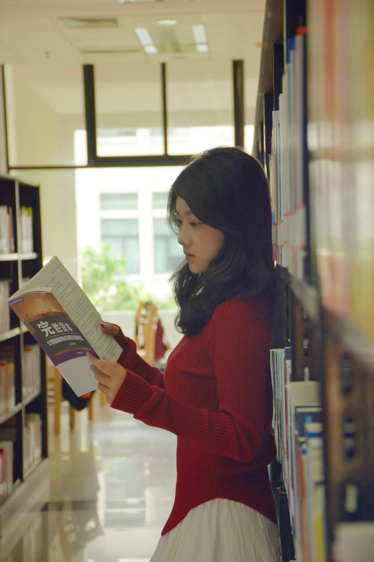 图书馆的书架间，总能遇见专注的身影。静谧美好的午后，书页簌簌翻动，阳光柔柔洒落。她沉浸在知识的海洋，我记下了她的专注。在书海间的每一次凝神，都是独属于考研人与知识相拥的浪漫。（摄影：陈等莅）