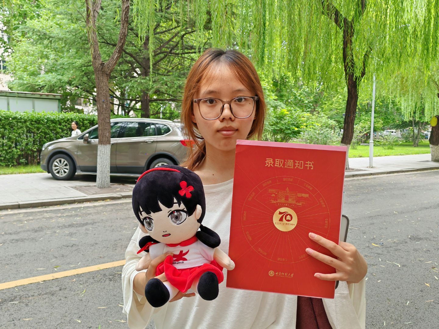 新生拿着录取通知书和小中合照