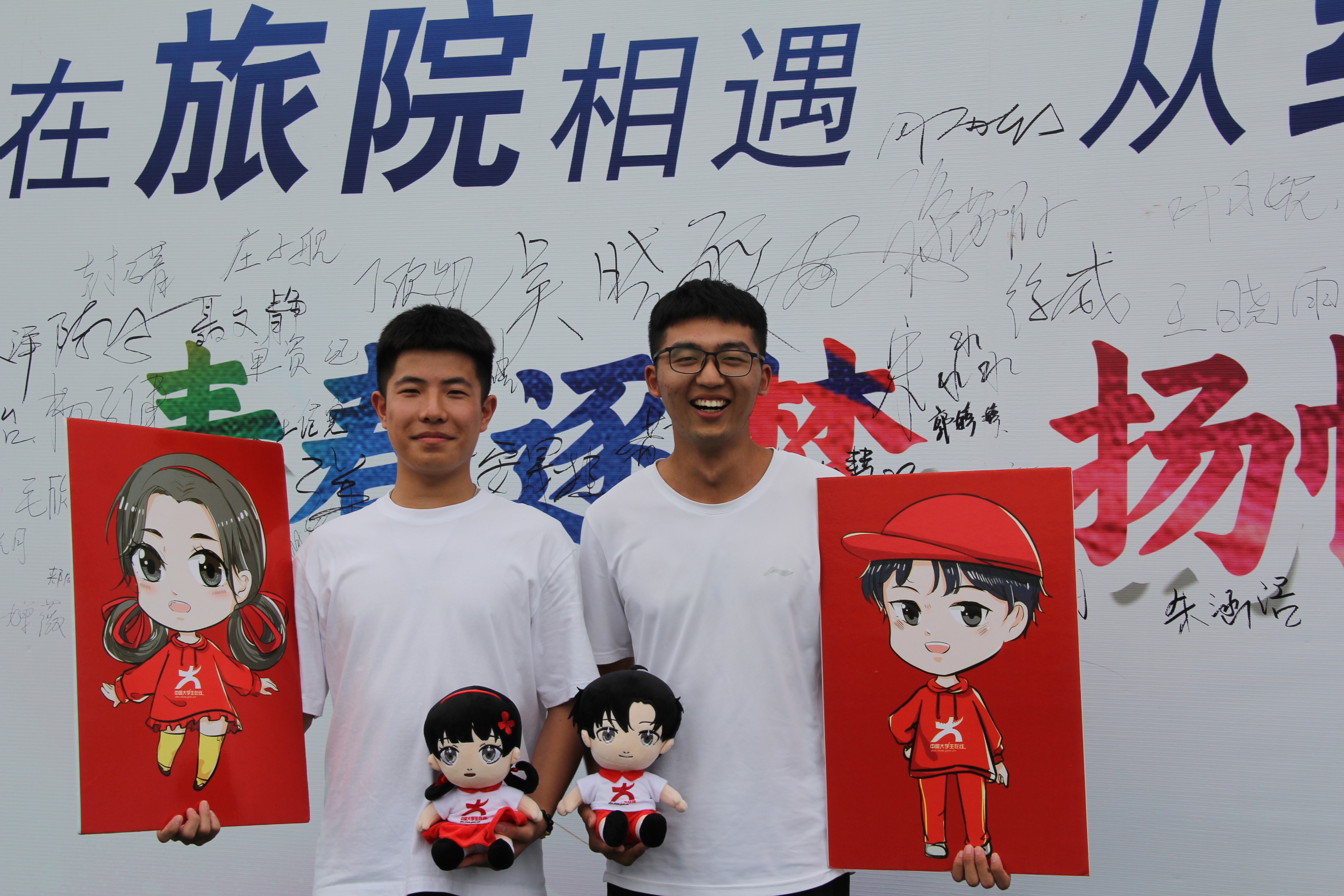 2023级新生在迎新签名墙与小中兄妹合影