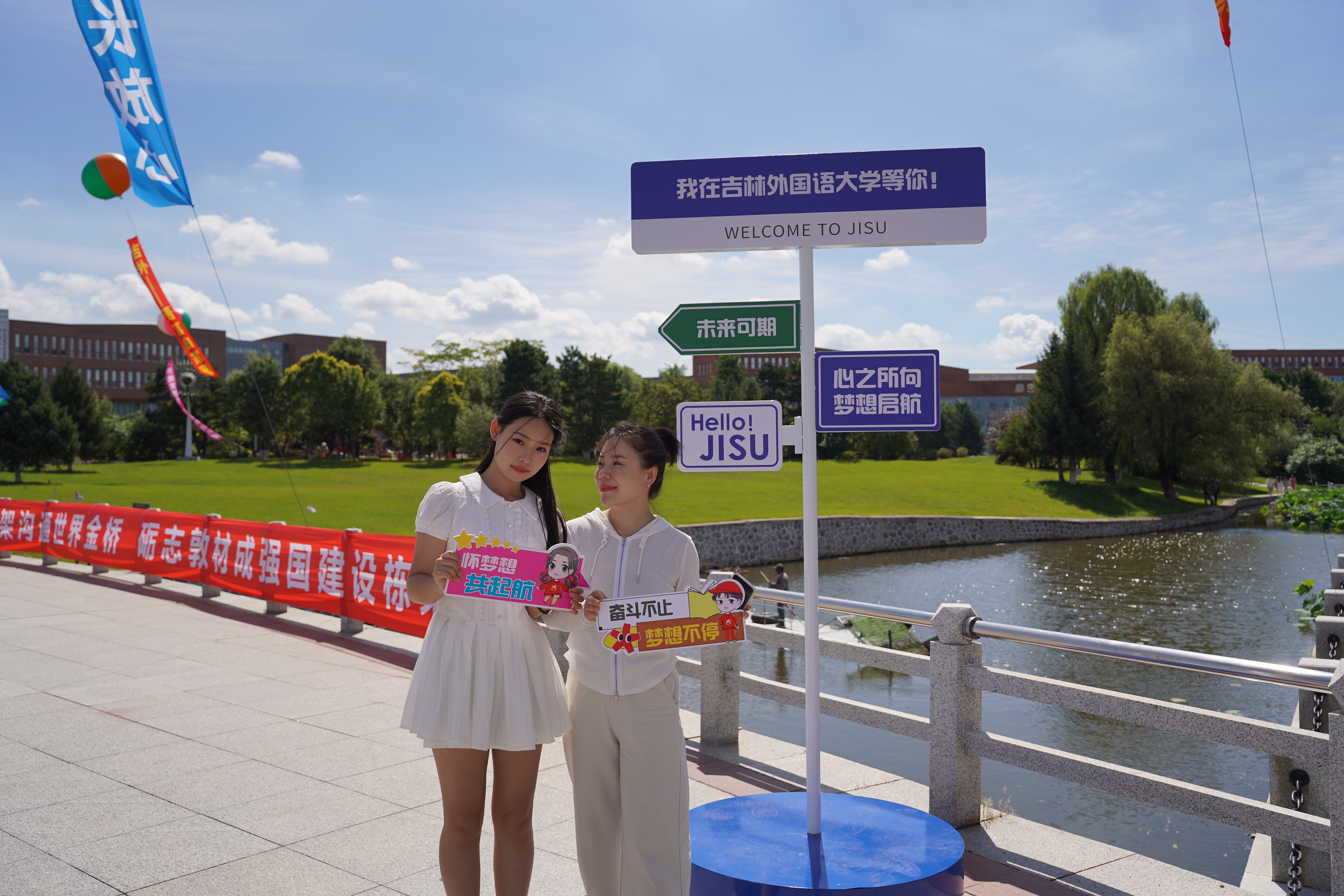 新生与家长校园湖景和远处建筑前合影留恋