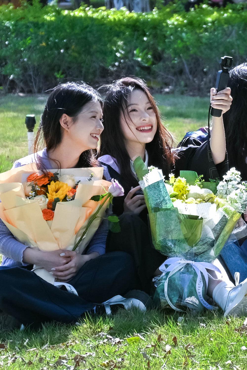 快门按下的前一秒，把头靠向挚友肩膀。怀里的向日葵开得正好，像极了宿舍阳台上养过的那一盆。原来最好的青春，是与你共享的悲欢。（摄影：庄语晴）
