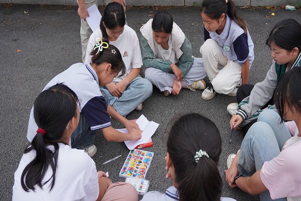 心理团辅课上孩子们共同设计队旗（安徽师范大学 崔晓冰 提供）
心理团辅活动是“萤火虫”的特色课程。队员们将心理素质教育与自身学前专业素养结合，帮助孩子们建立心灵的坚固城堡，携手踏上筑梦心灵之旅。