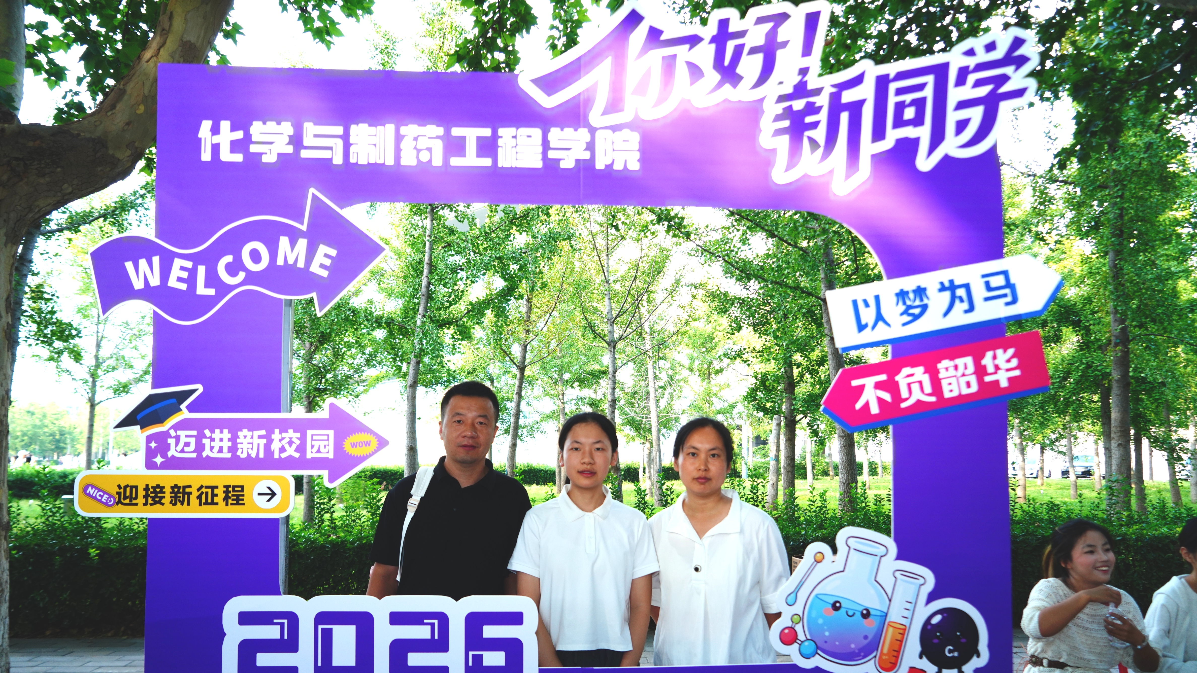 化学与制药工程学院迎新打卡现场，新生和家人在 2026 主题拍照框前留下入学纪念合照
