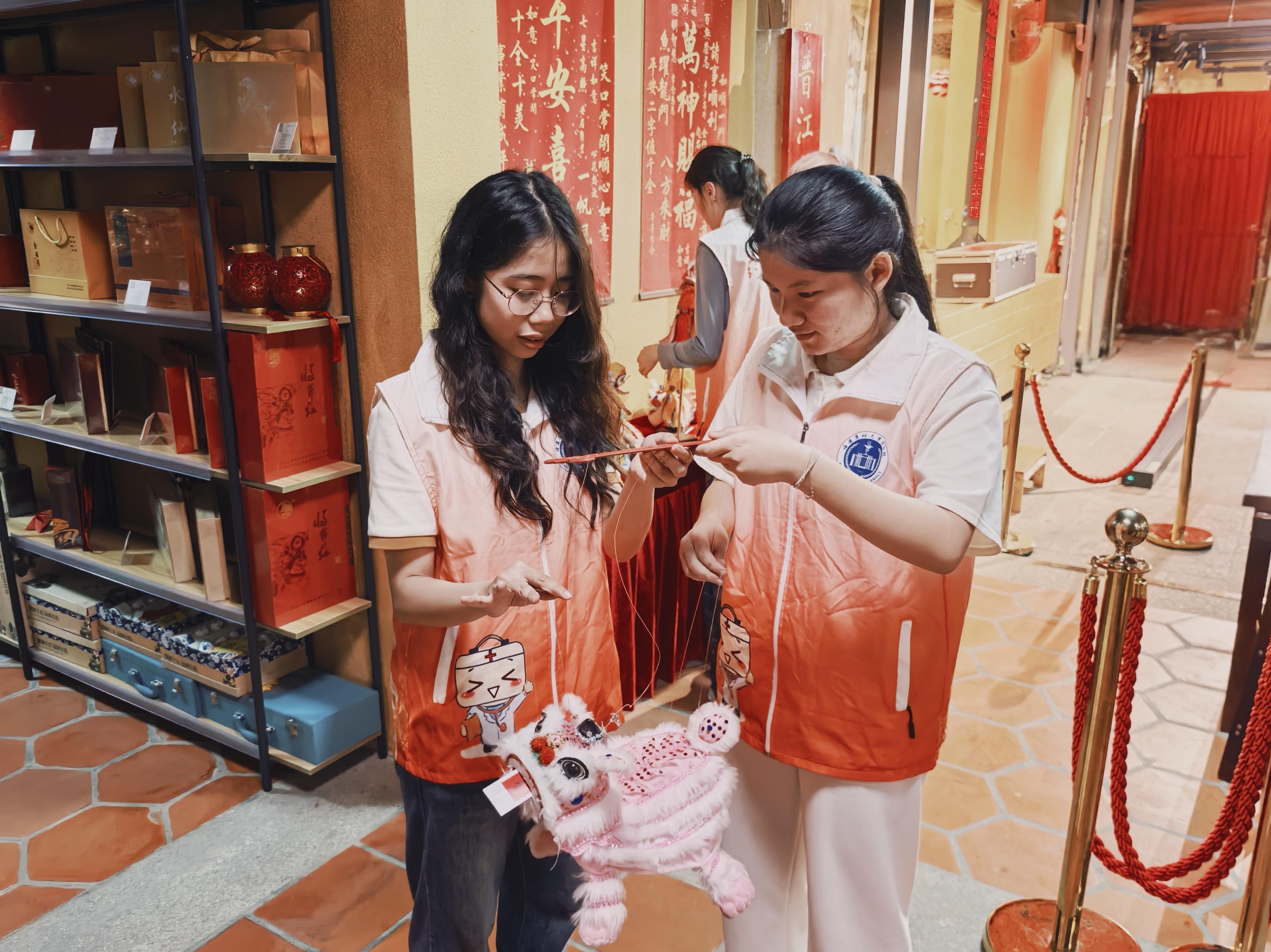 队长程欣和队员陆佳欢在闽南非遗体验馆里练习提线木偶__童庆楠供图[1].jpg