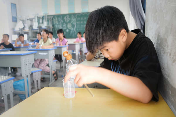 化学实验课上孩子在认真地做实验（安徽师范大学 刘雨涵 提供）
为了激发孩子们的科学梦，队员选择让他们亲自模拟火山喷发的实验，这也在他们心里种下了一颗敬畏自然、保护环境的种子。